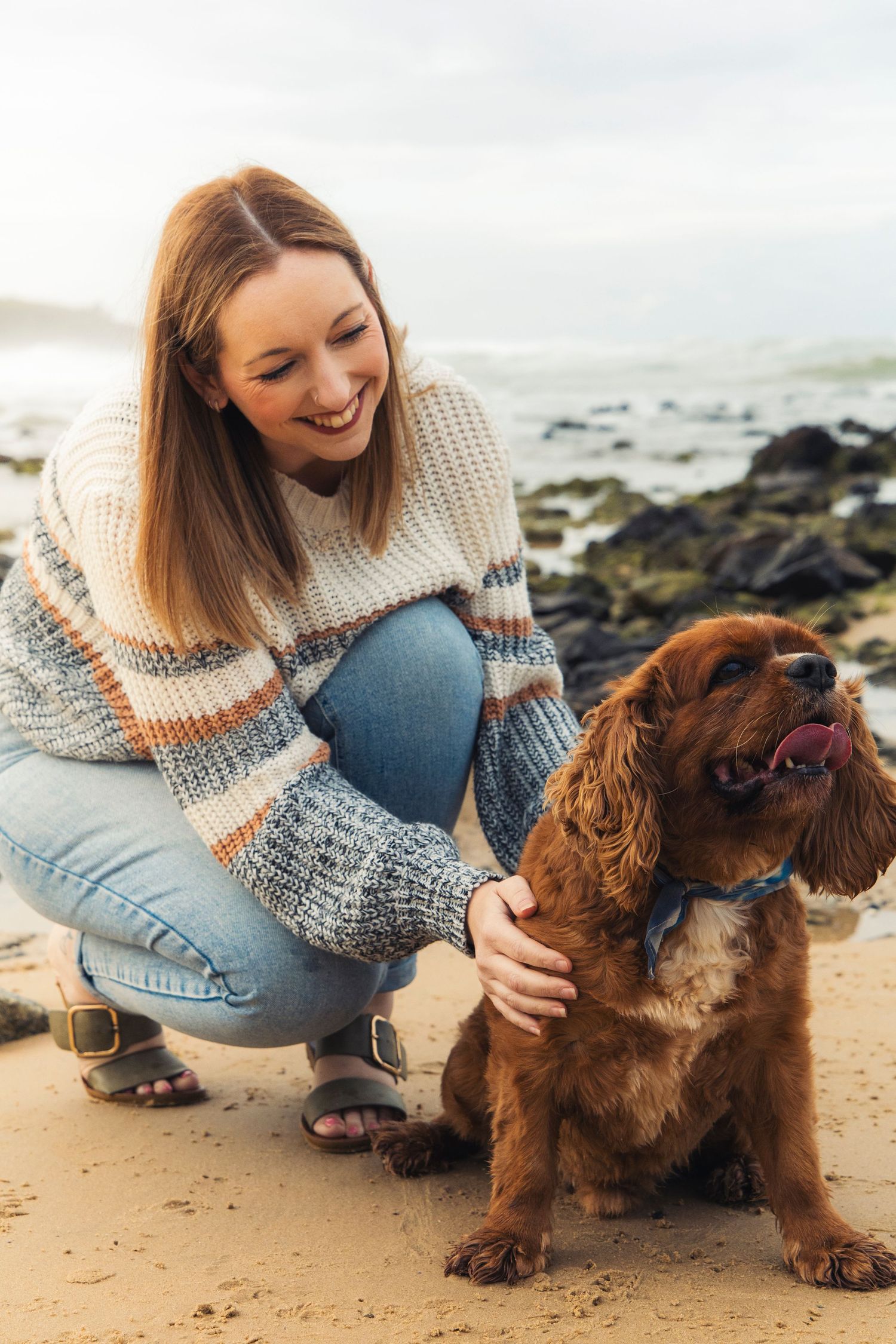 A woman with her dog at the beach