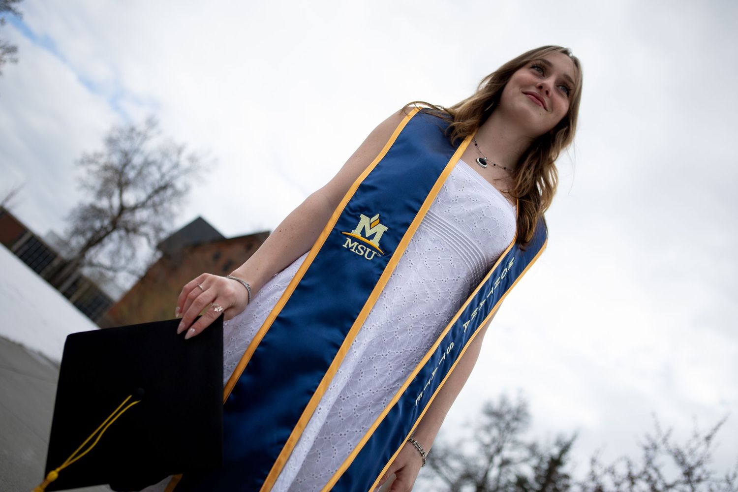 A Montana State University Grad holds her cap in Bozeman, Montana.