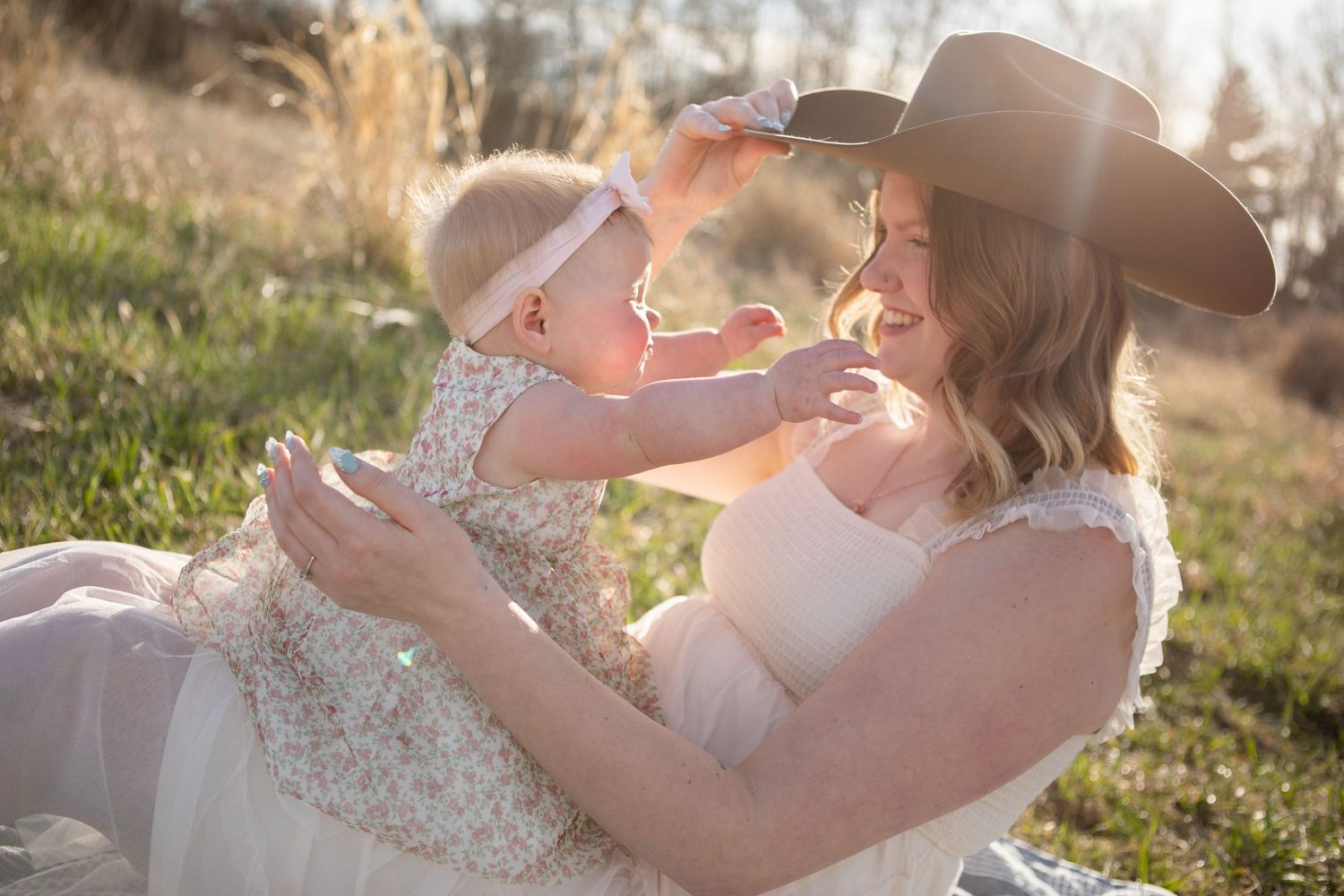 A Bozeman mom and her daughter play with a cowboy hat during a Mother's Day Session in Bozeman, Montana.