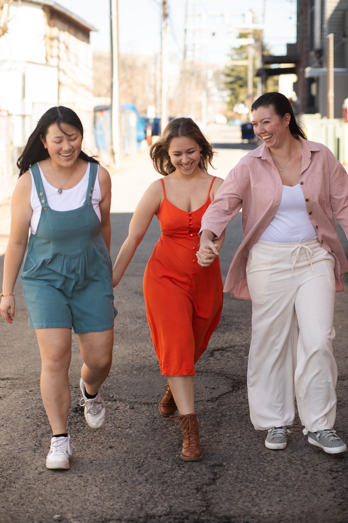A group of friends holding hands as they walk down the street in downtown Bozeman, Montana.