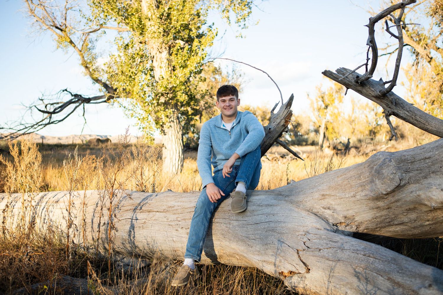 A Montana Senior sitting on a fallen tree in Eastern Montana.