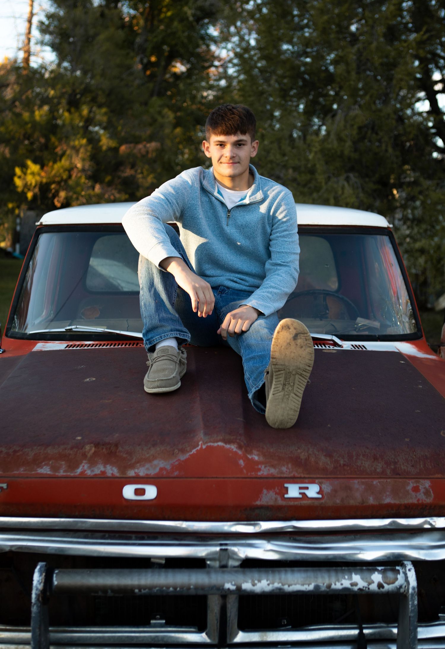 A Bozeman senior sitting on a old Ford truck in Montana.