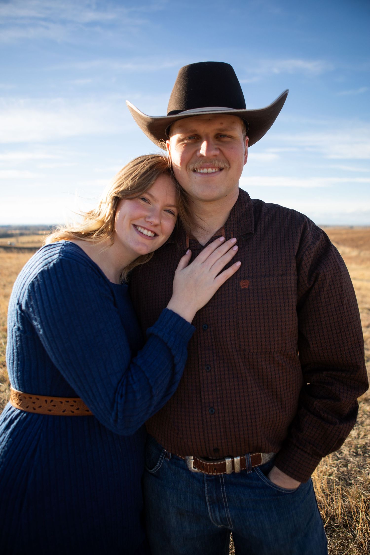 A Bozeman couple stands together in a field.