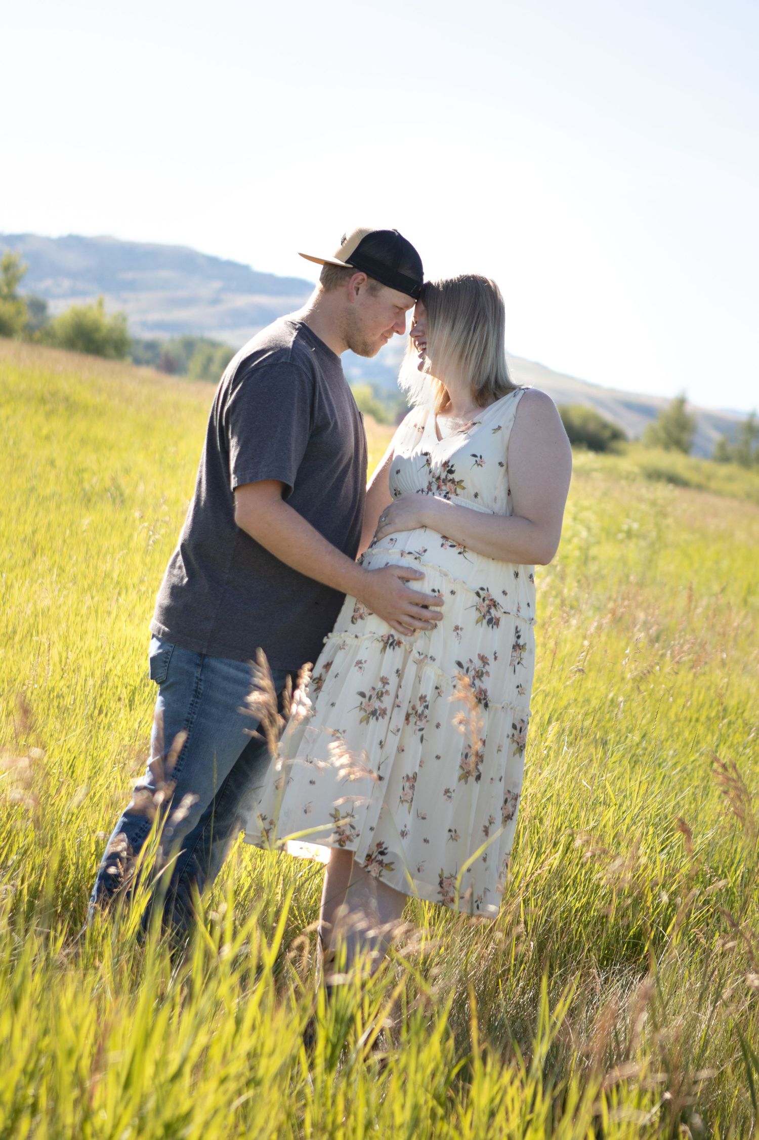A Bozeman couple pressing their heads together during a maternity session in Gallatin Valley.