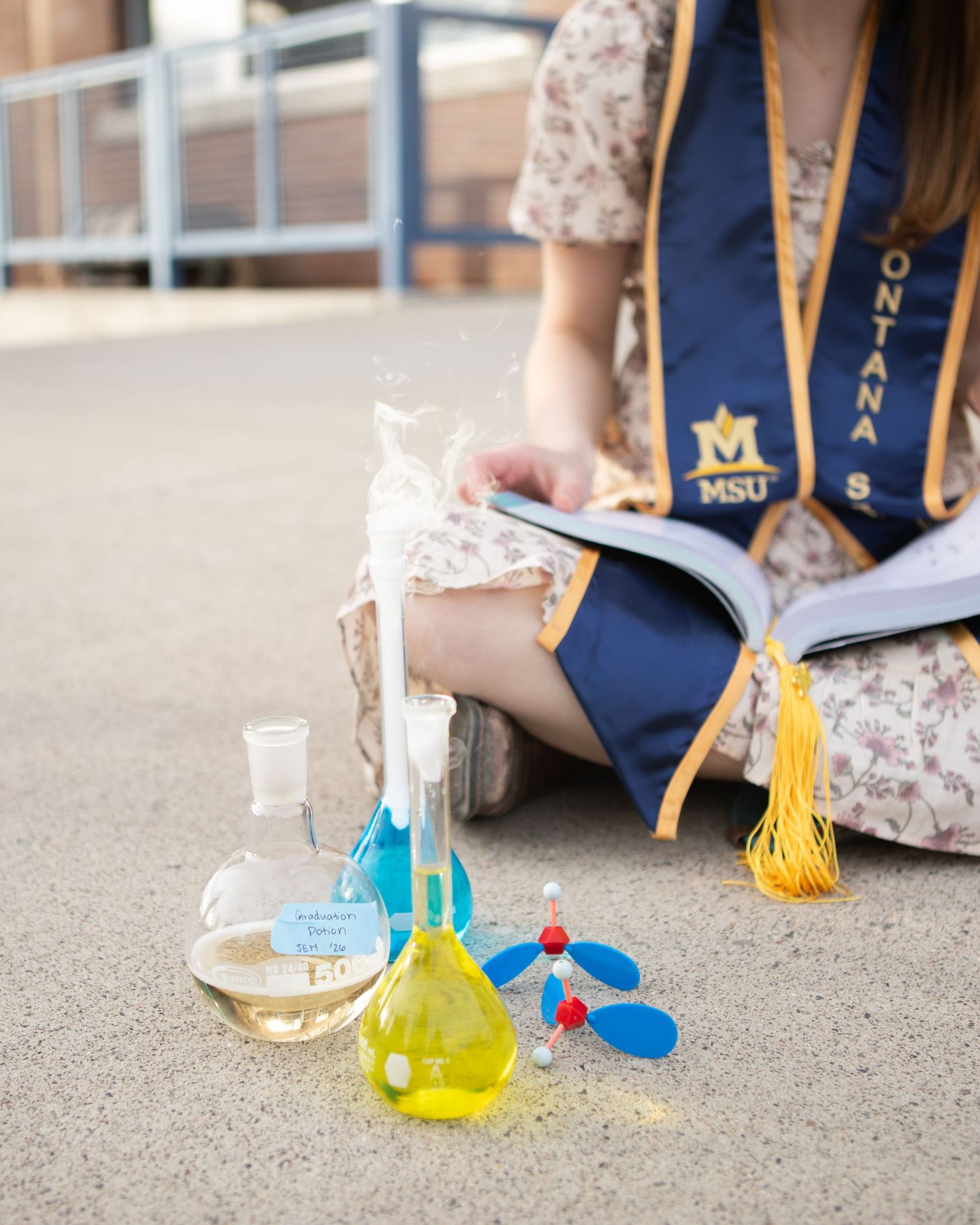 A Montana State grad sits with her beakers in Bozeman.