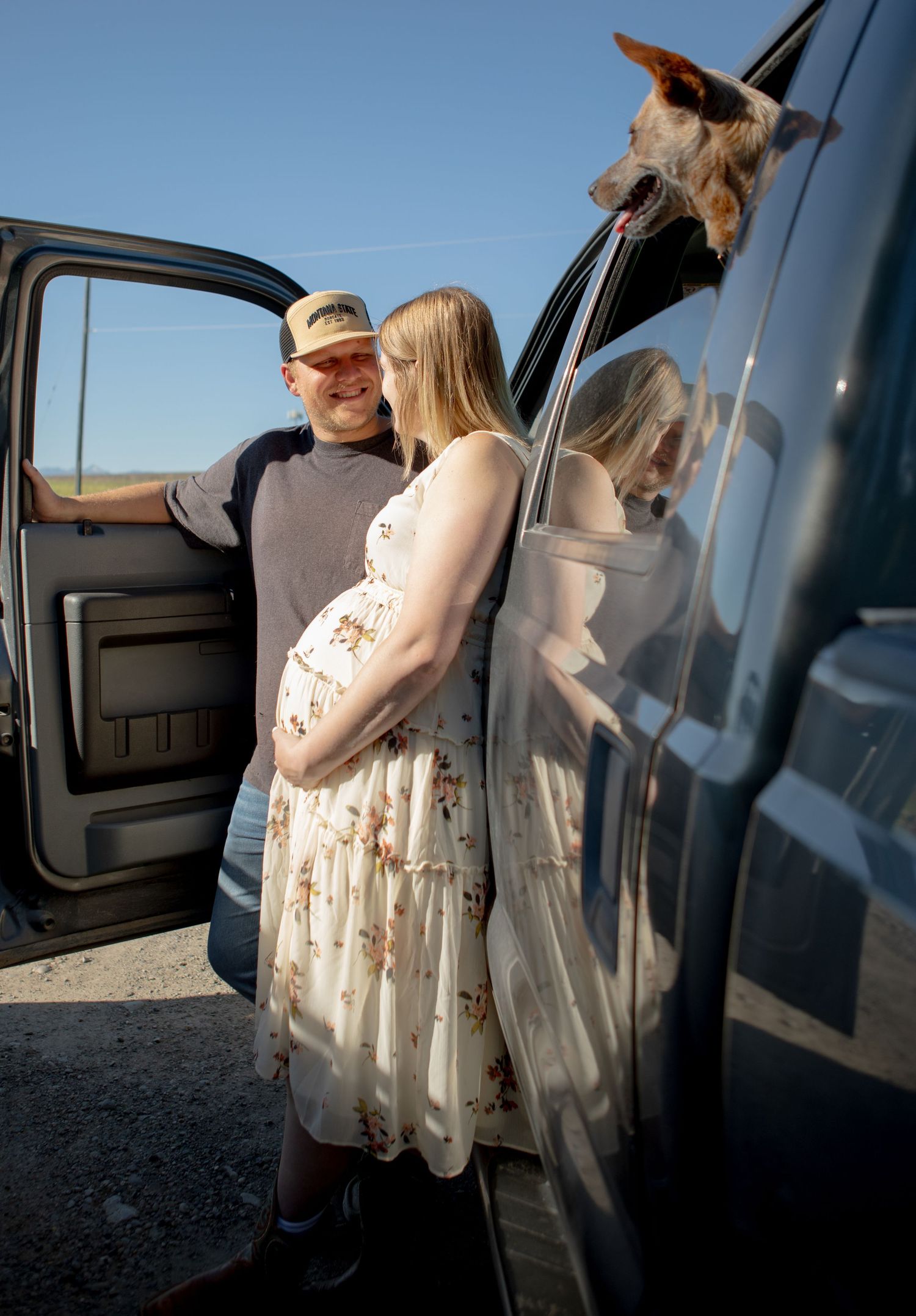 Bozeman couple standing against their truck with their dog in the window in Bozeman, Montana