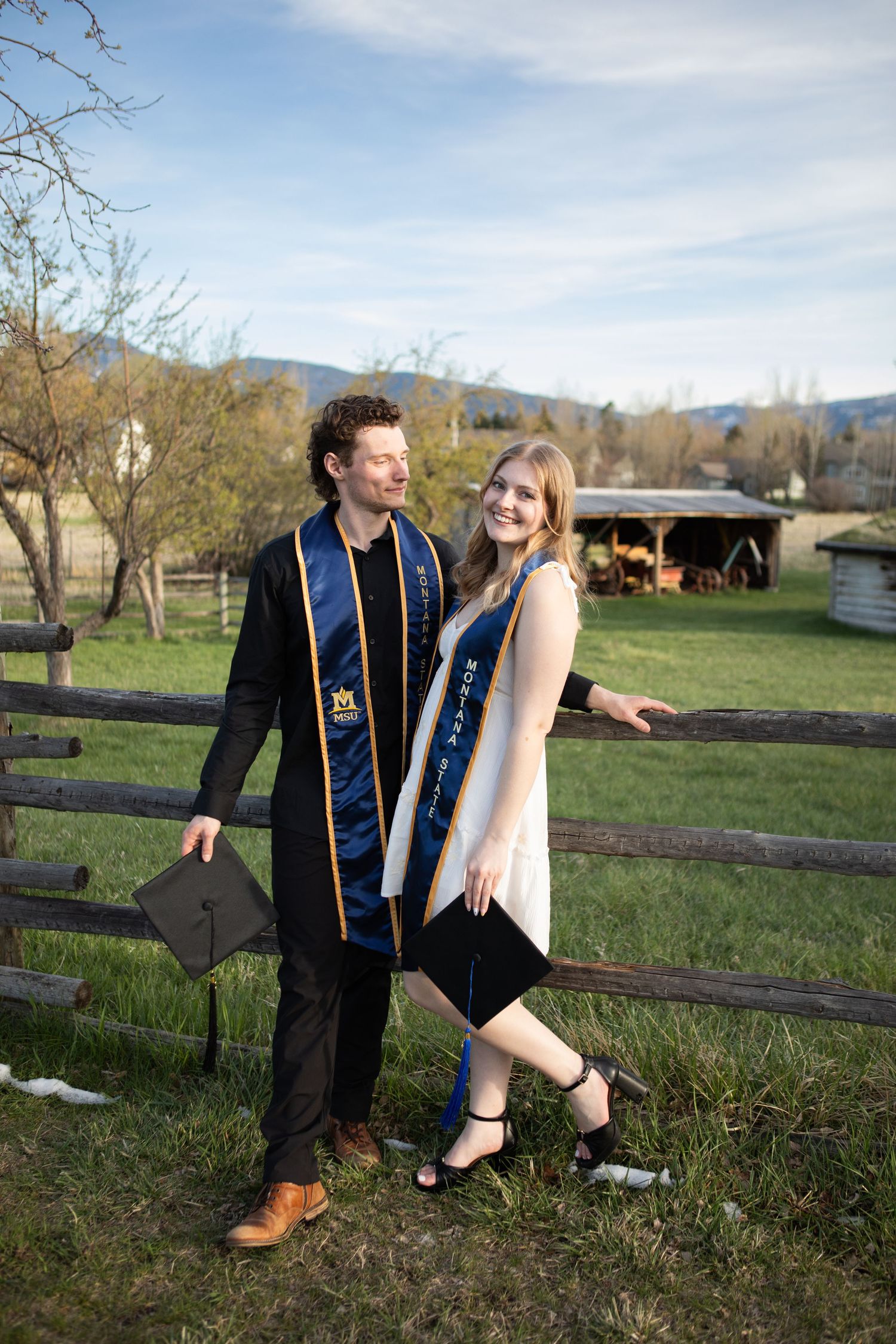A Montana State University Couple stand against a fence in Bozeman, Montana.