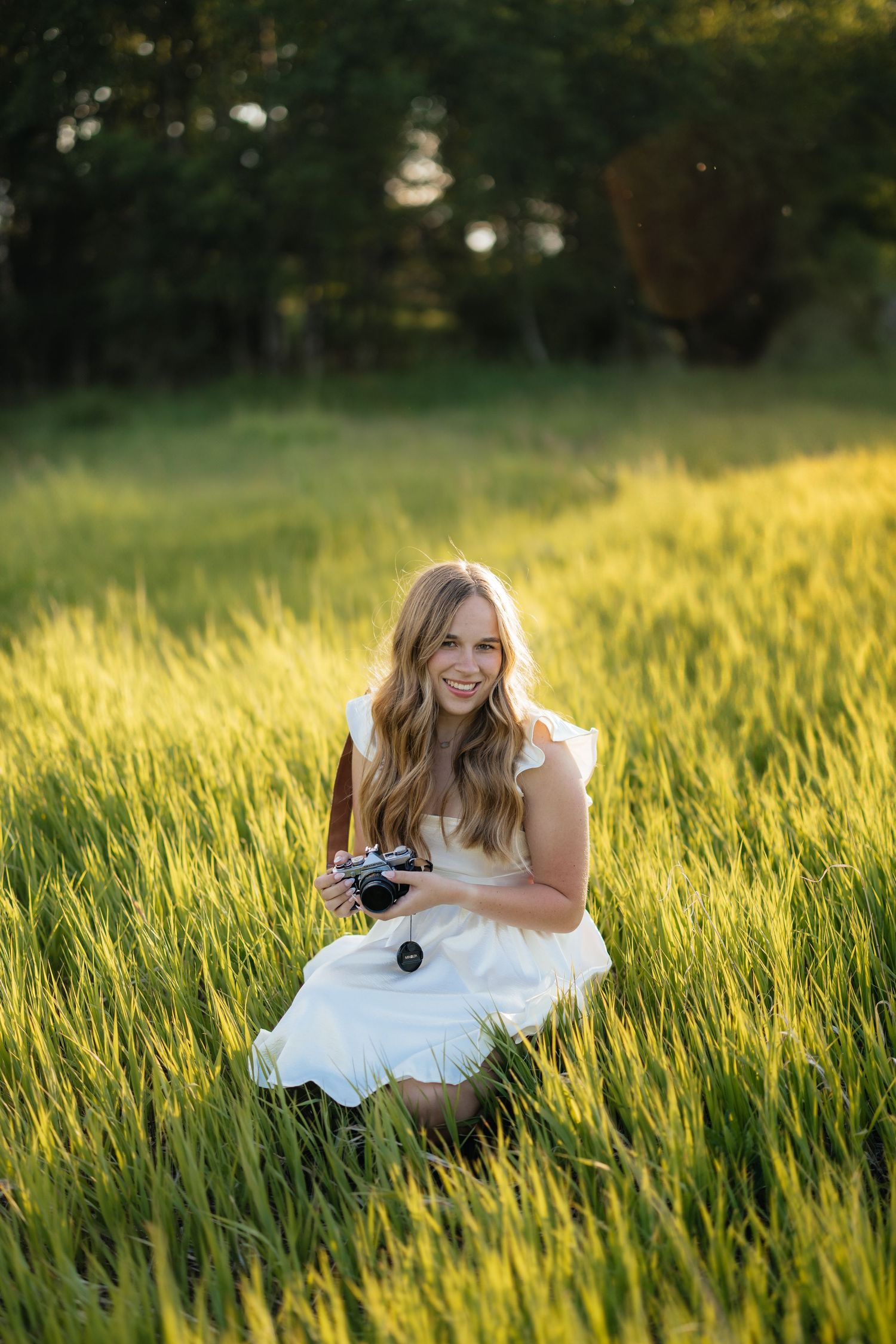 Photographer Sierrah Elizabeth holding her camera in a field in Bozeman, Montana. (Photo by Mallory Jean Photography)