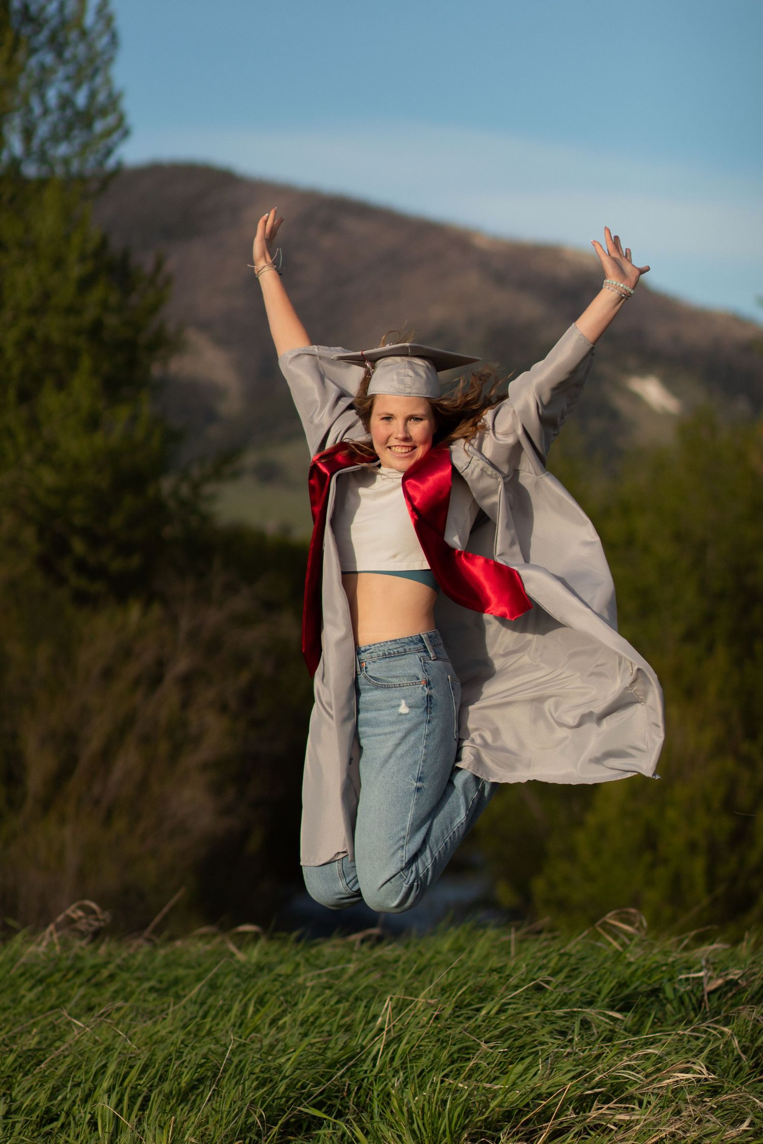 A Bozeman Senior jumps in her gown in front of the 