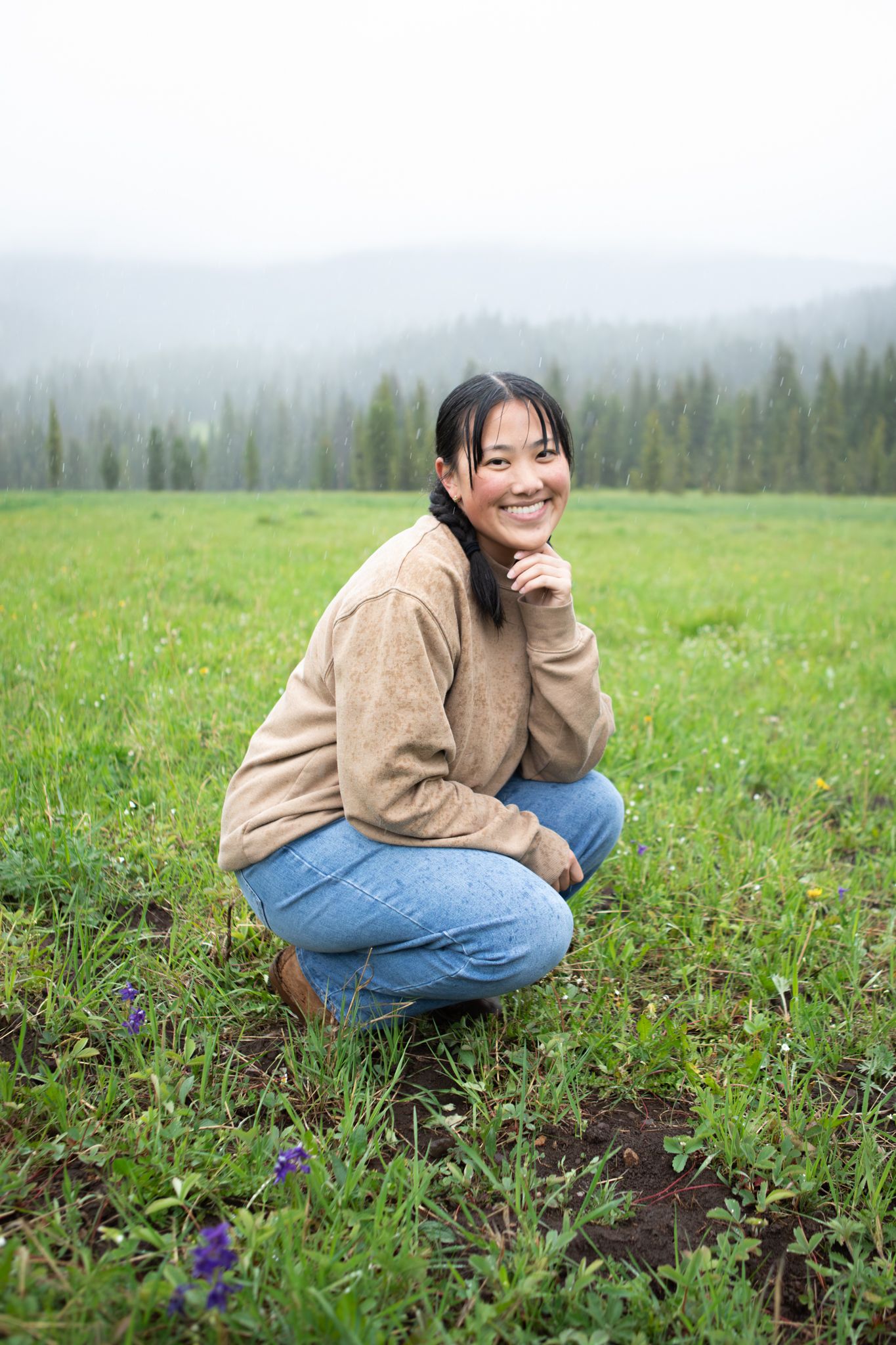 A Bozeman senior squats in front of the mountains in Hyalite Canyon.