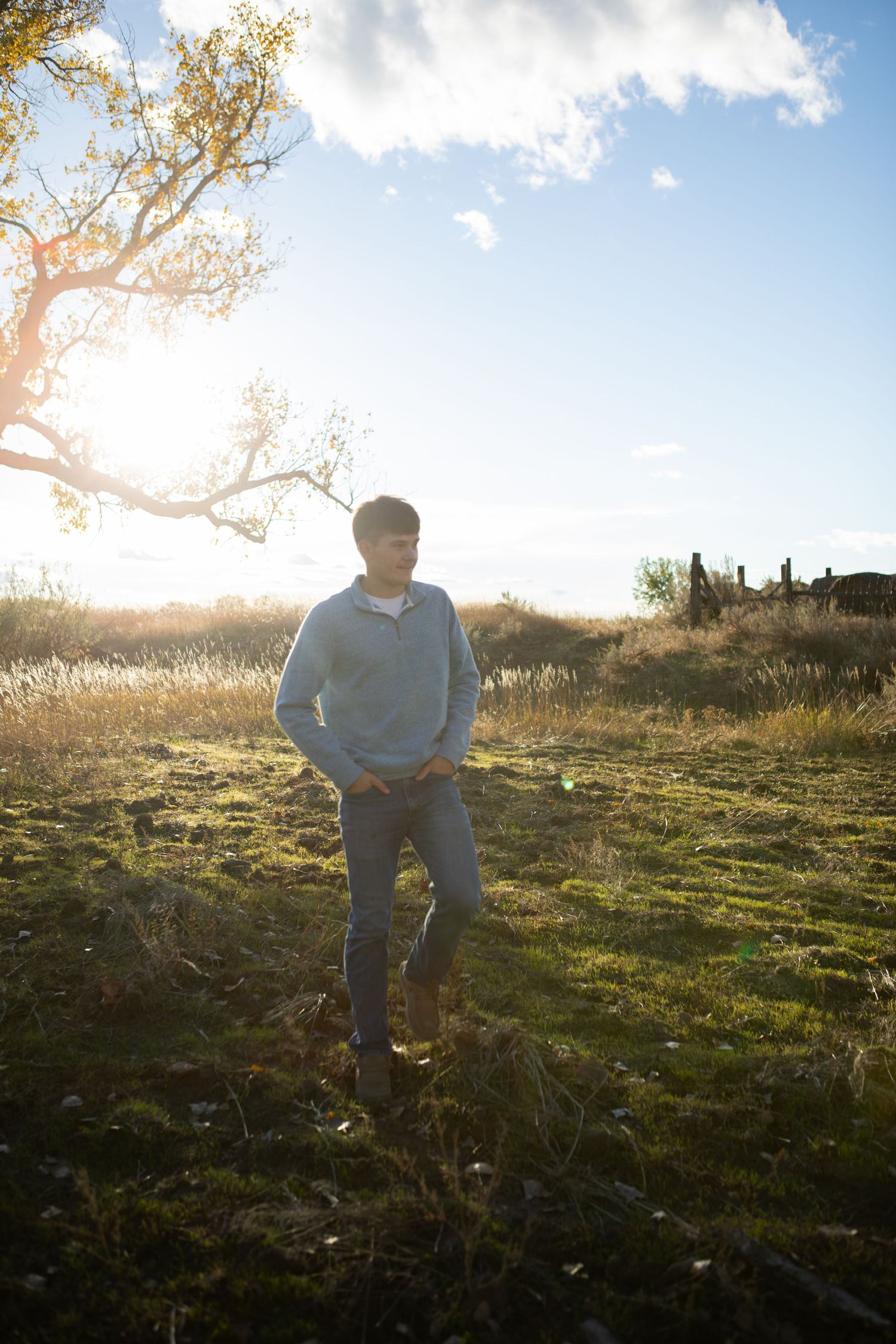 A Bozeman senior walking through a field at sunset in Montana.