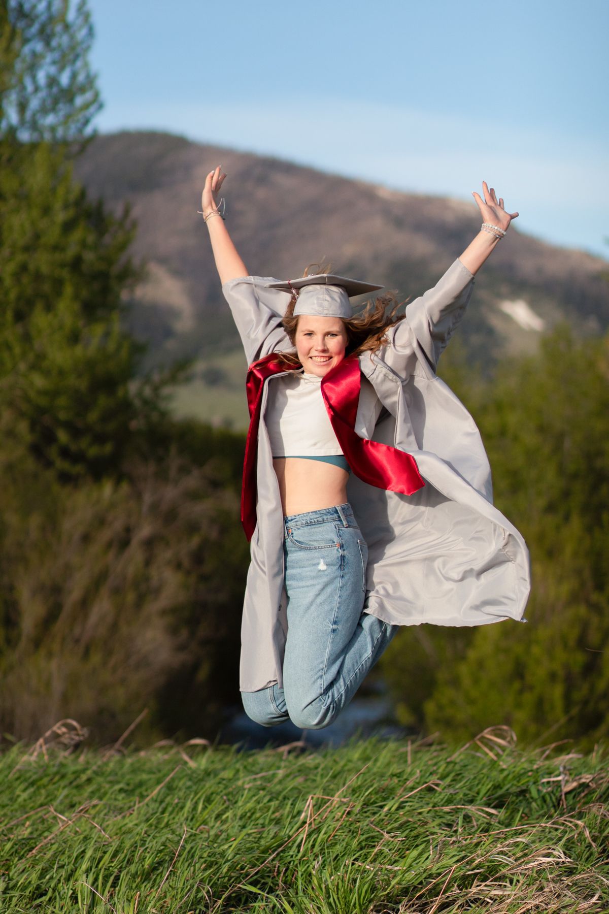 A Bozeman Senior jumping in celebration in front of the Bridger Mountains.