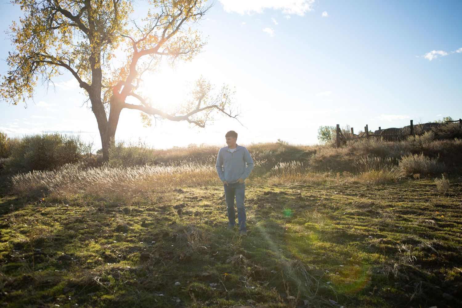 A Bozeman senior walking through a field at sunset in Montana.