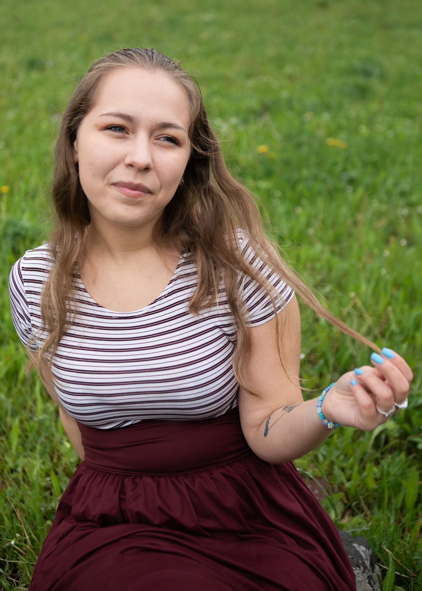 A Montana senior plays with her hair while sitting.