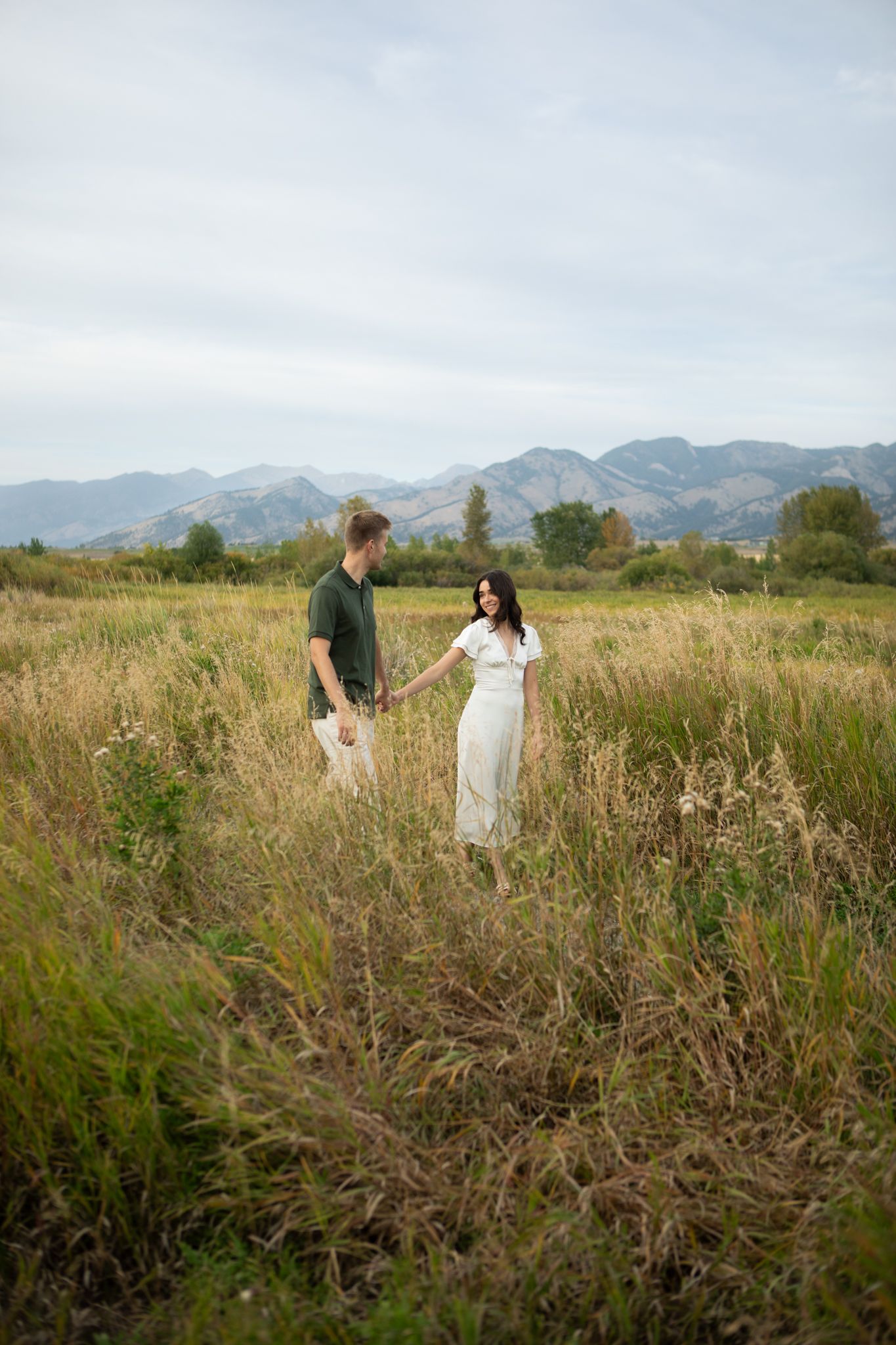 A newly engaged Montana Couple walks through a field in Bozeman, Montana for their engagement photos.