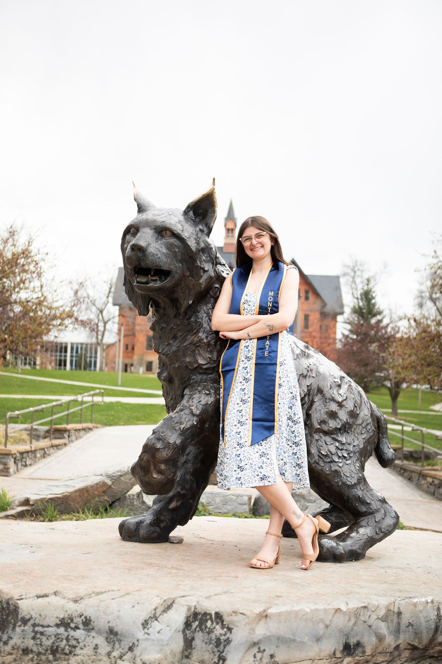 A Montana State University Grad leaning against Spirt the Bobcat.