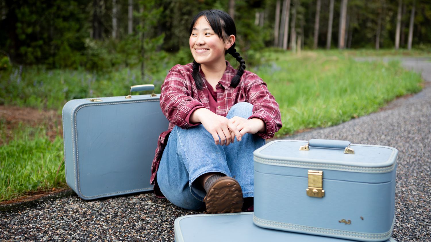 A Montana Senior sits in Hyalite Canyon amongst Suitcases outside of Bozeman, Montana.