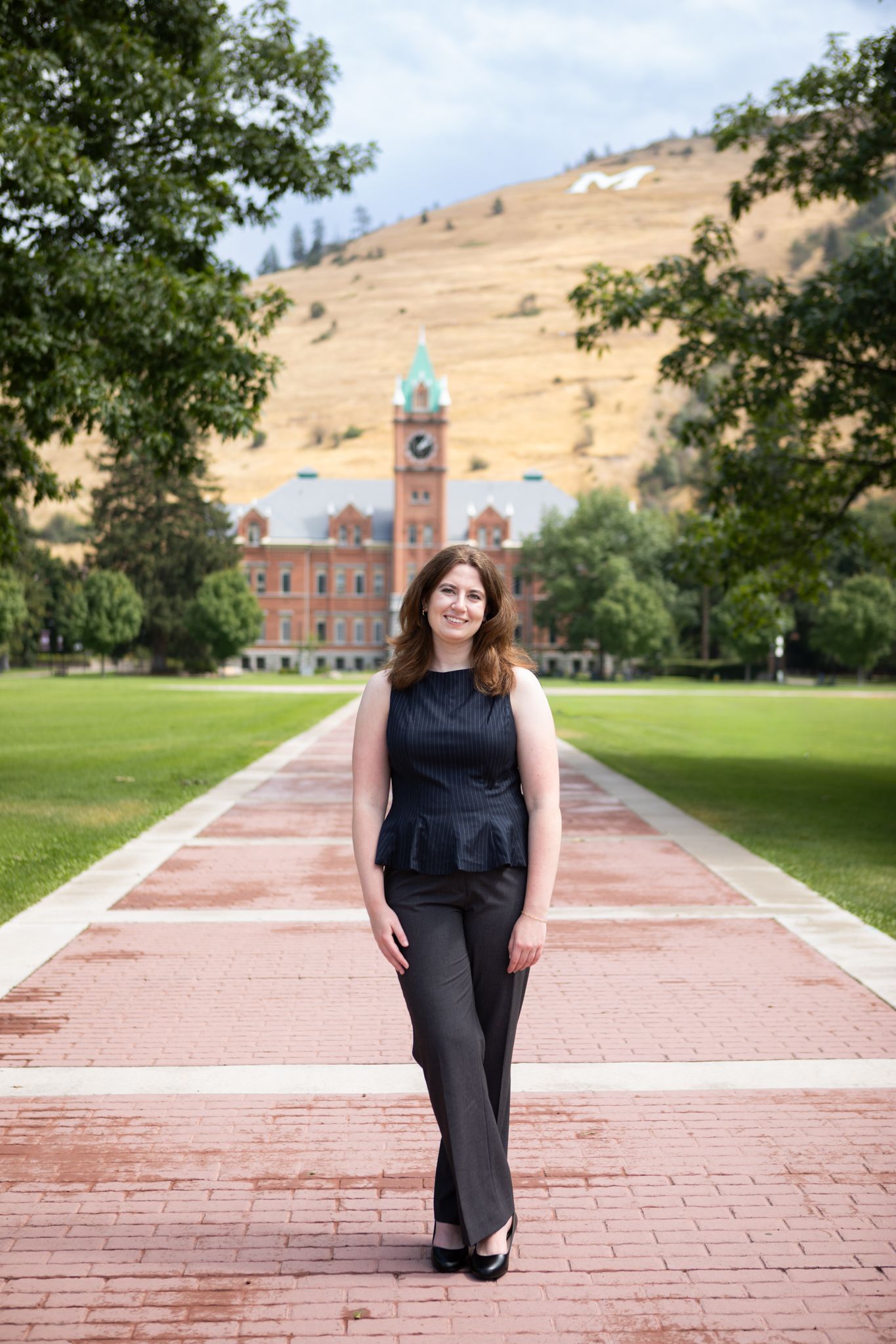 University of Montana Grad stands in front of University Hall in Missoula, Montana.