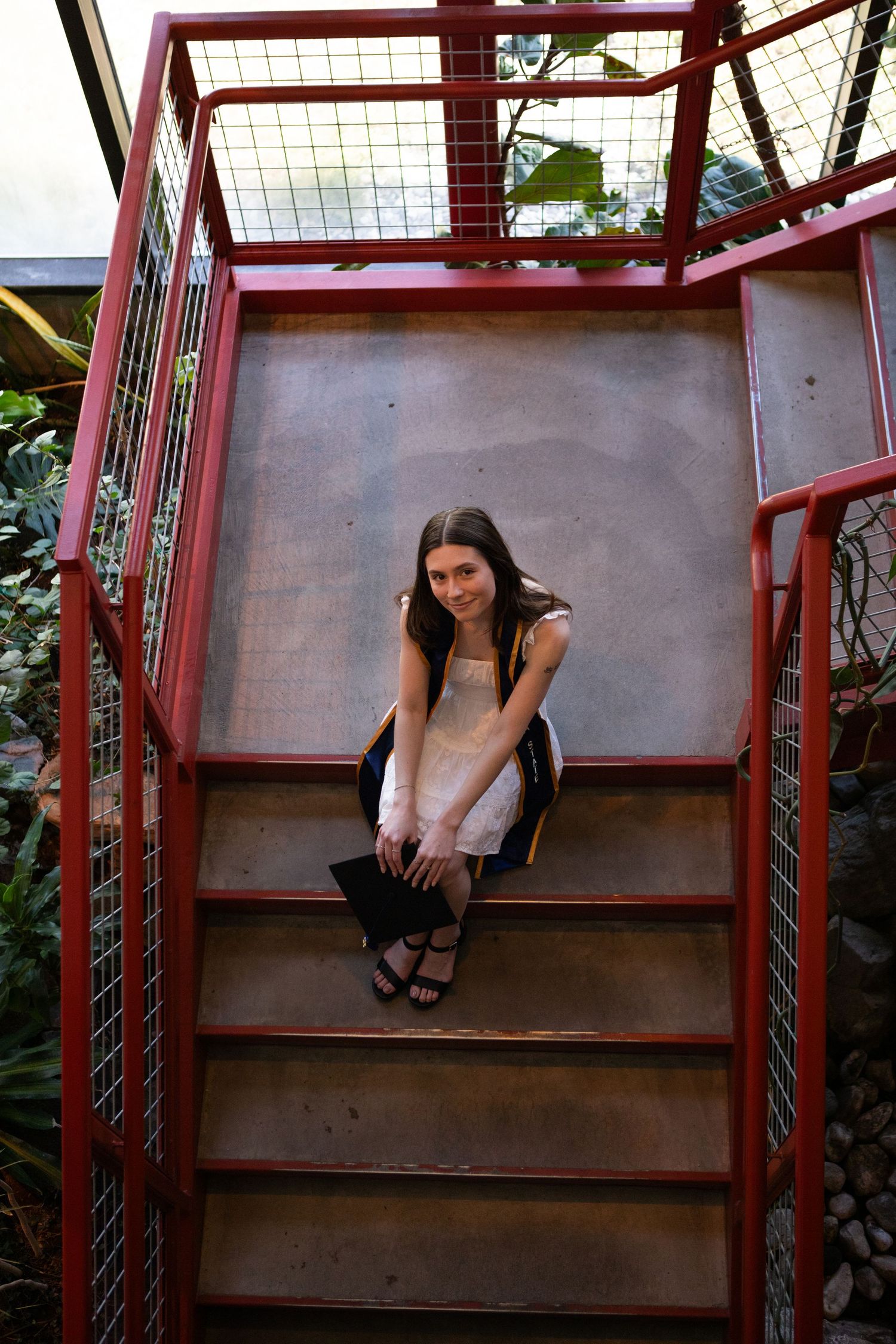 A Montana State University Grad sits on the stairs of the Plant Growth Center in Bozeman, Montana.
