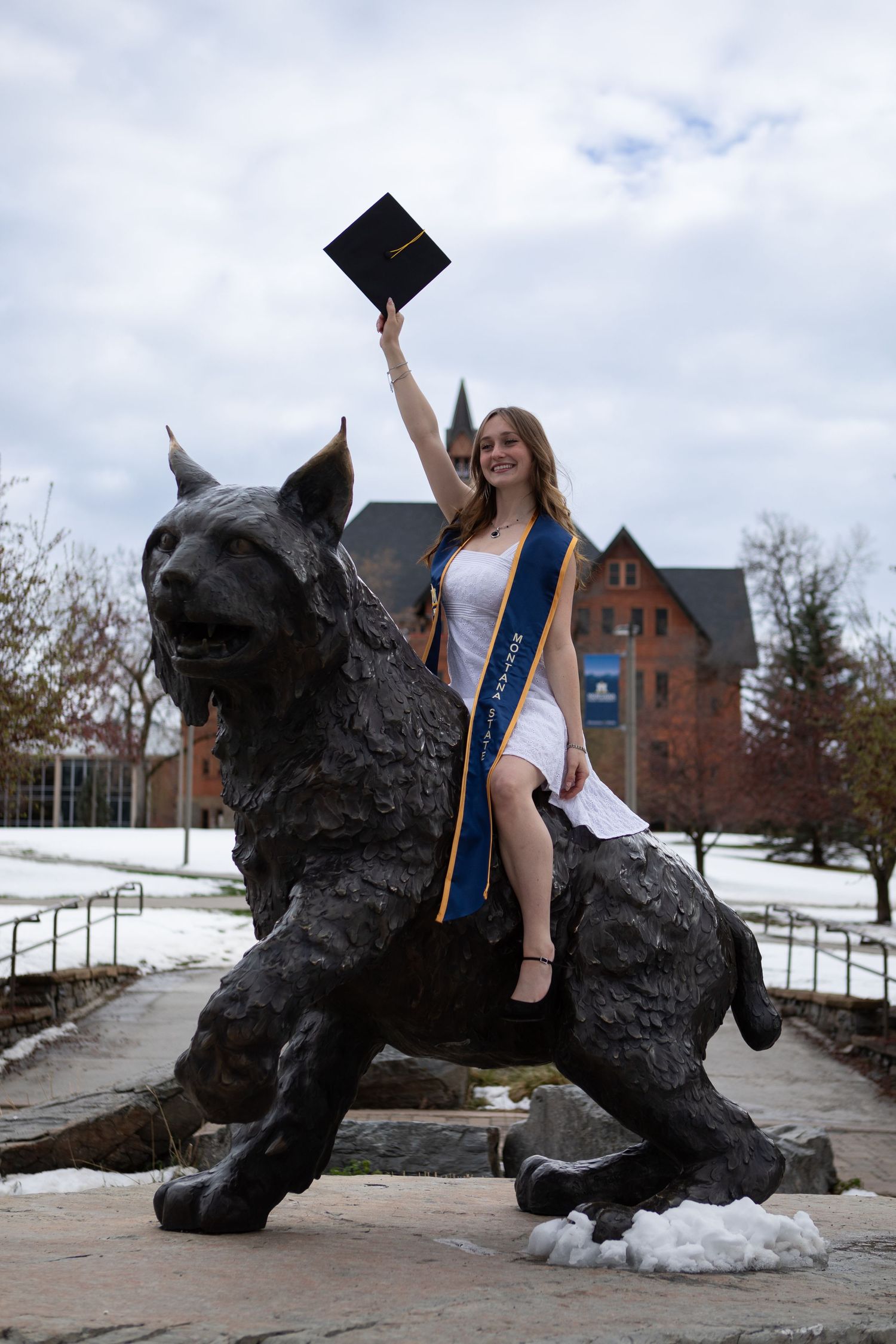 A Montana State University sits on top of Spirit the Bobcat in Bozeman, Montana.