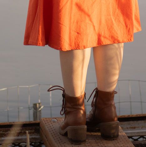 Detail image of a Montana Senior, close up to shoes standing in front of water