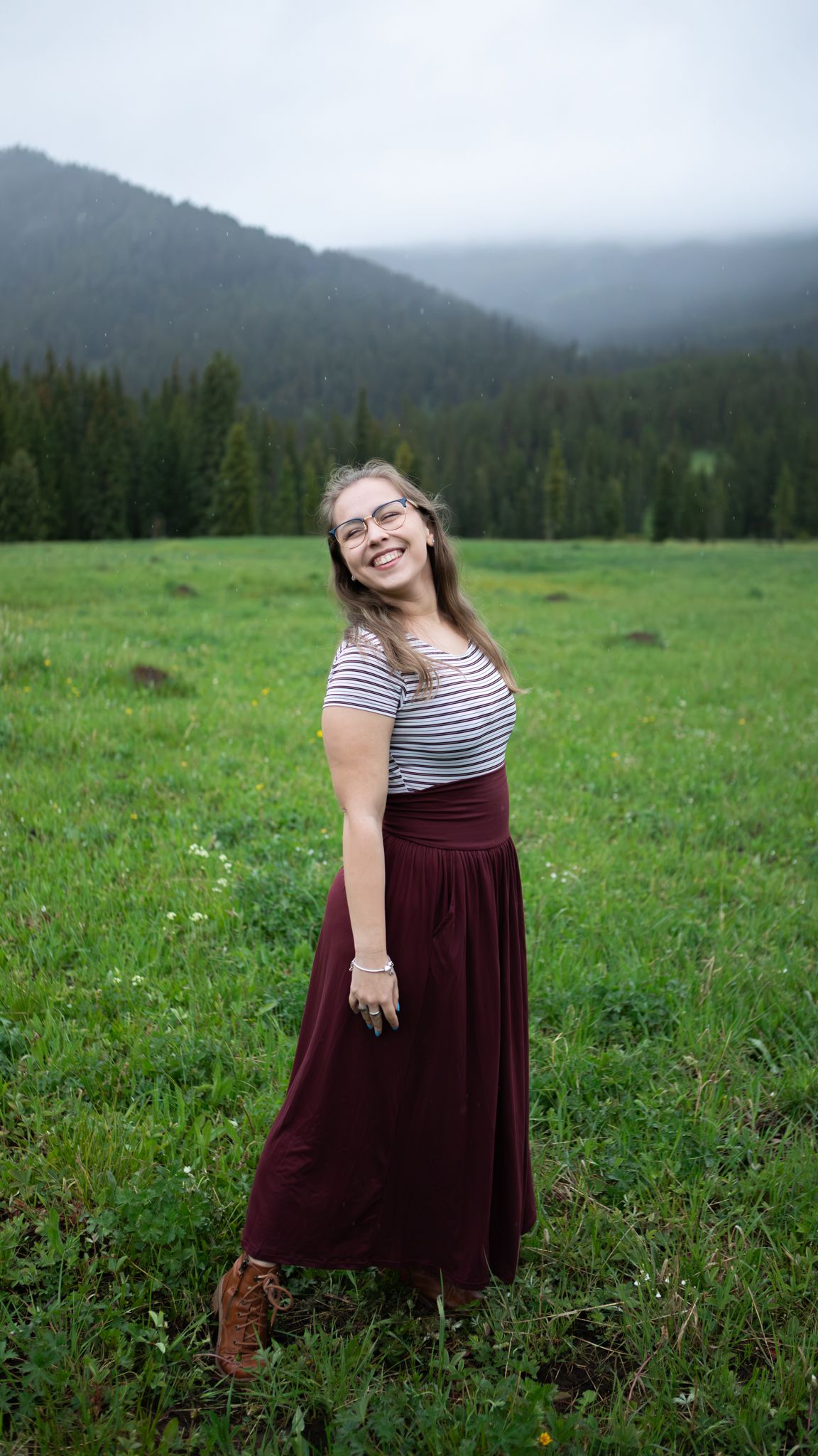 A Montana senior poses in front of mountains.