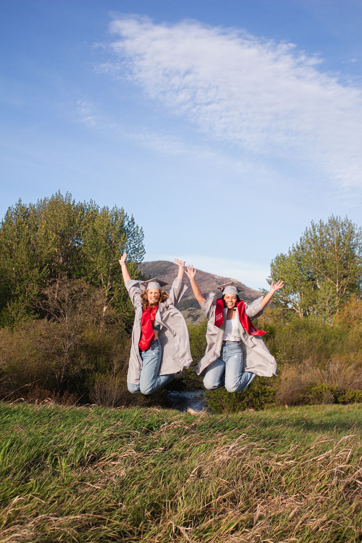 Bozeman Seniors jumping in celebration in a field in the Gallatin Valley.