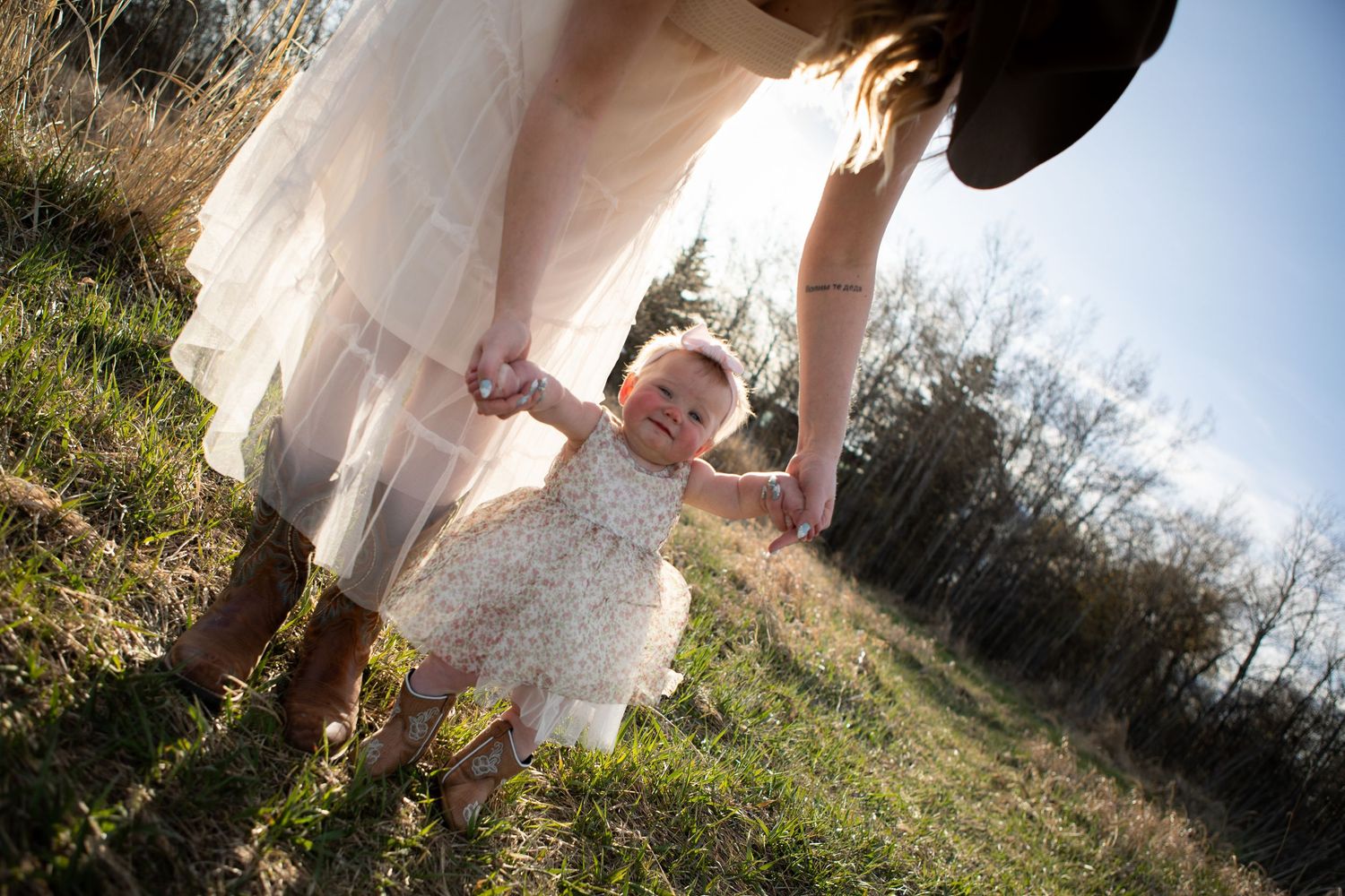 A Bozeman mom walks her baby in a field during a Mother's Day Session in Bozeman, Montana.