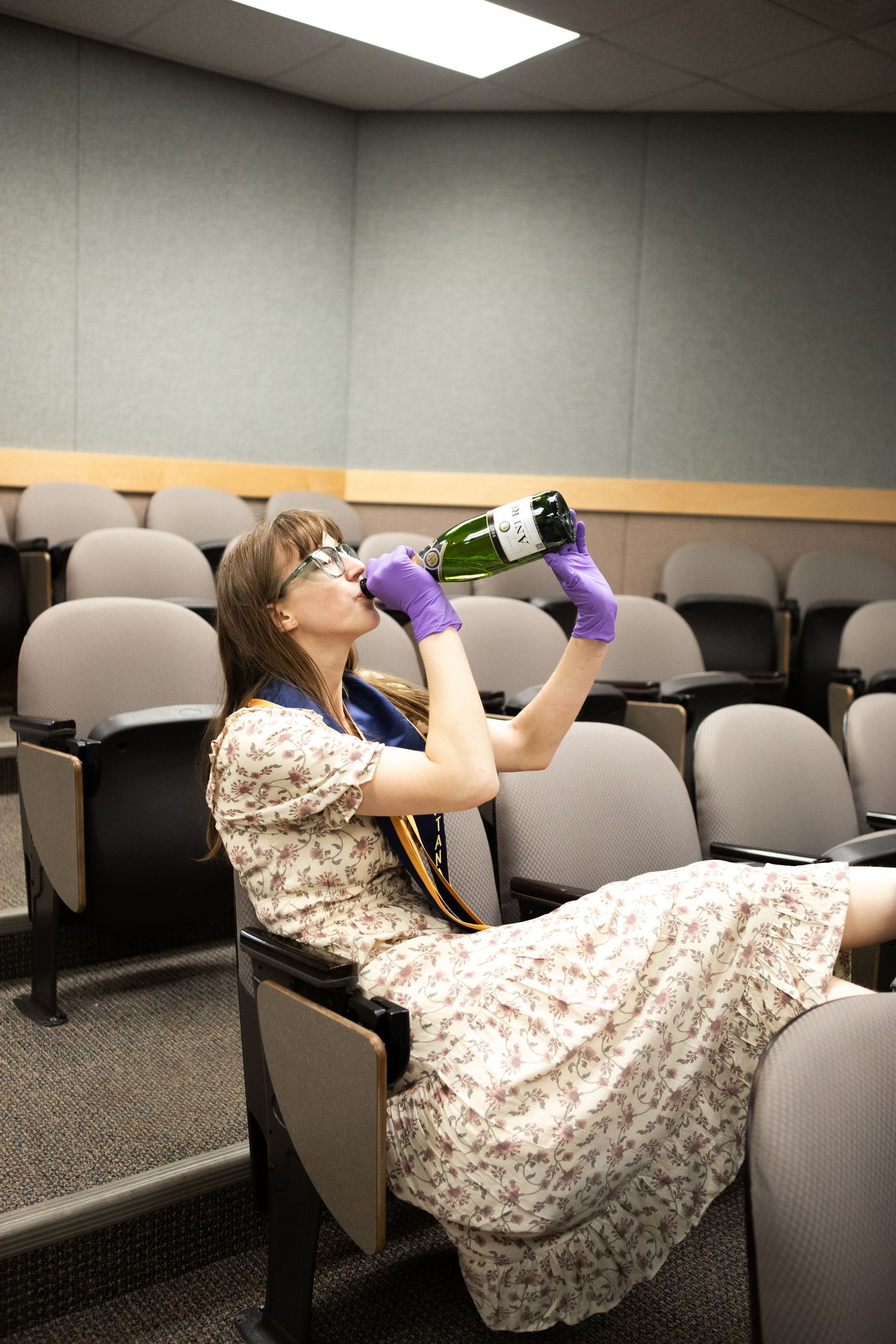 A Montana State University grad drinks champagne in the Chemistry Biochemistry Building in Bozeman.
