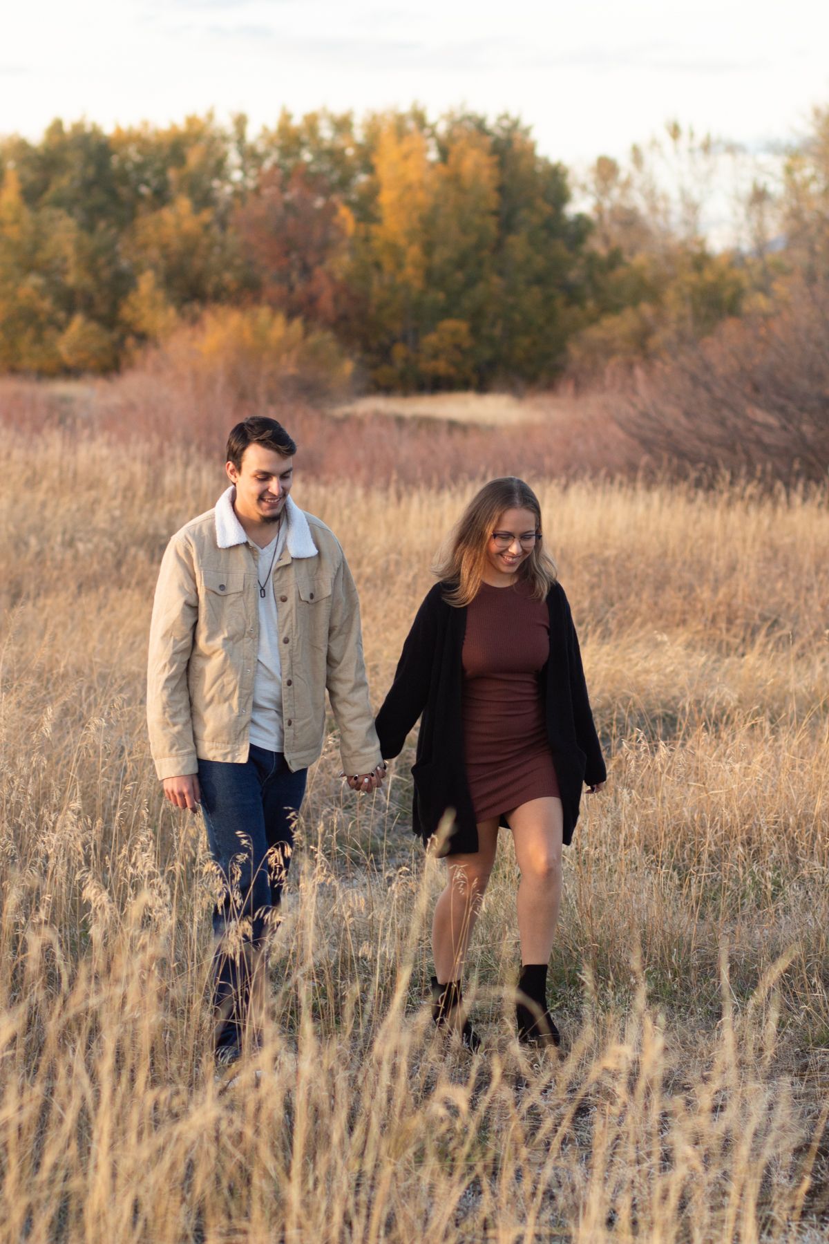 A Bozeman Couple walking together through a field in Bozeman.