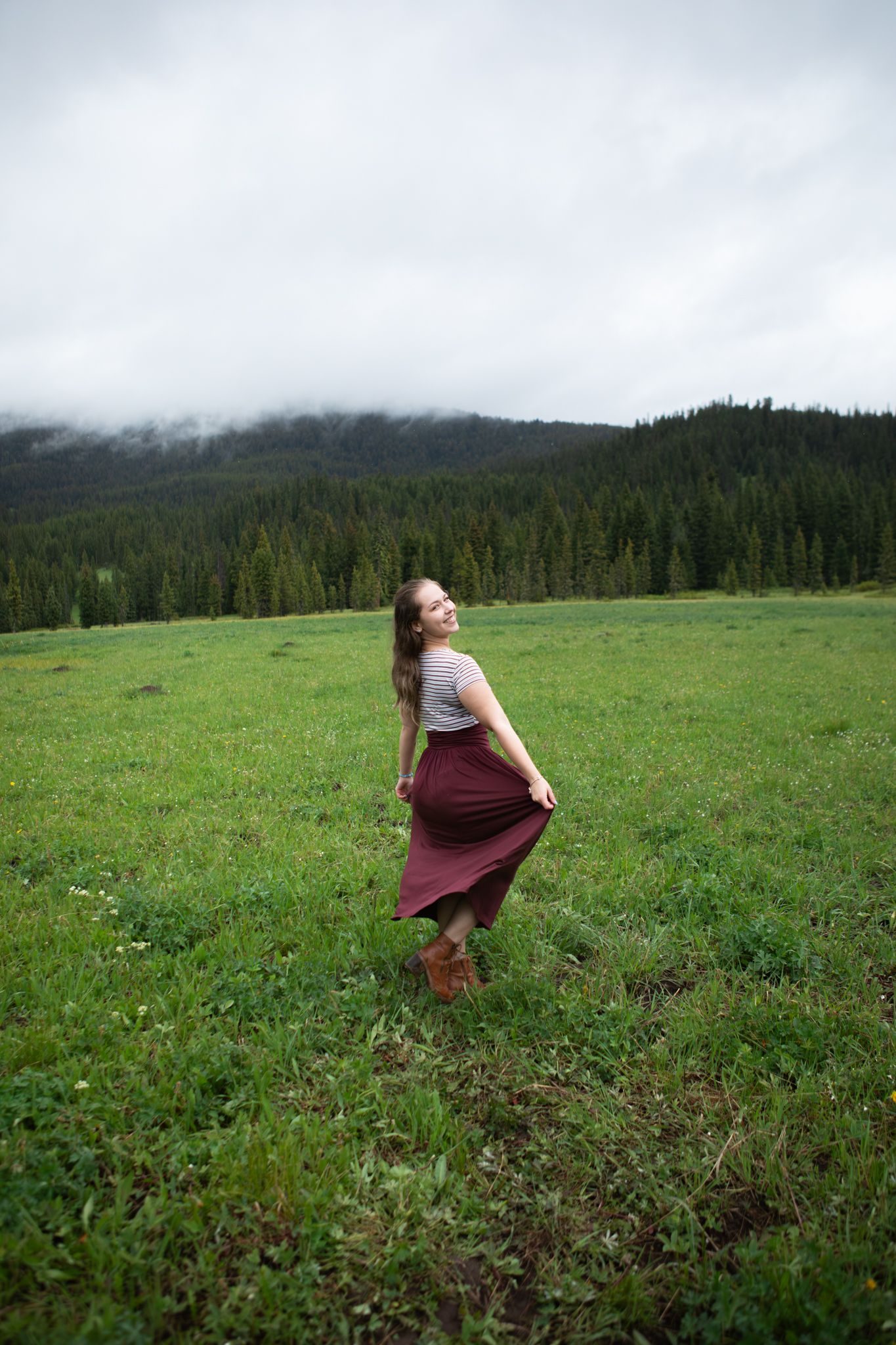 A Bozeman senior spins in a field in front of mountains in Hyalite Canyon.