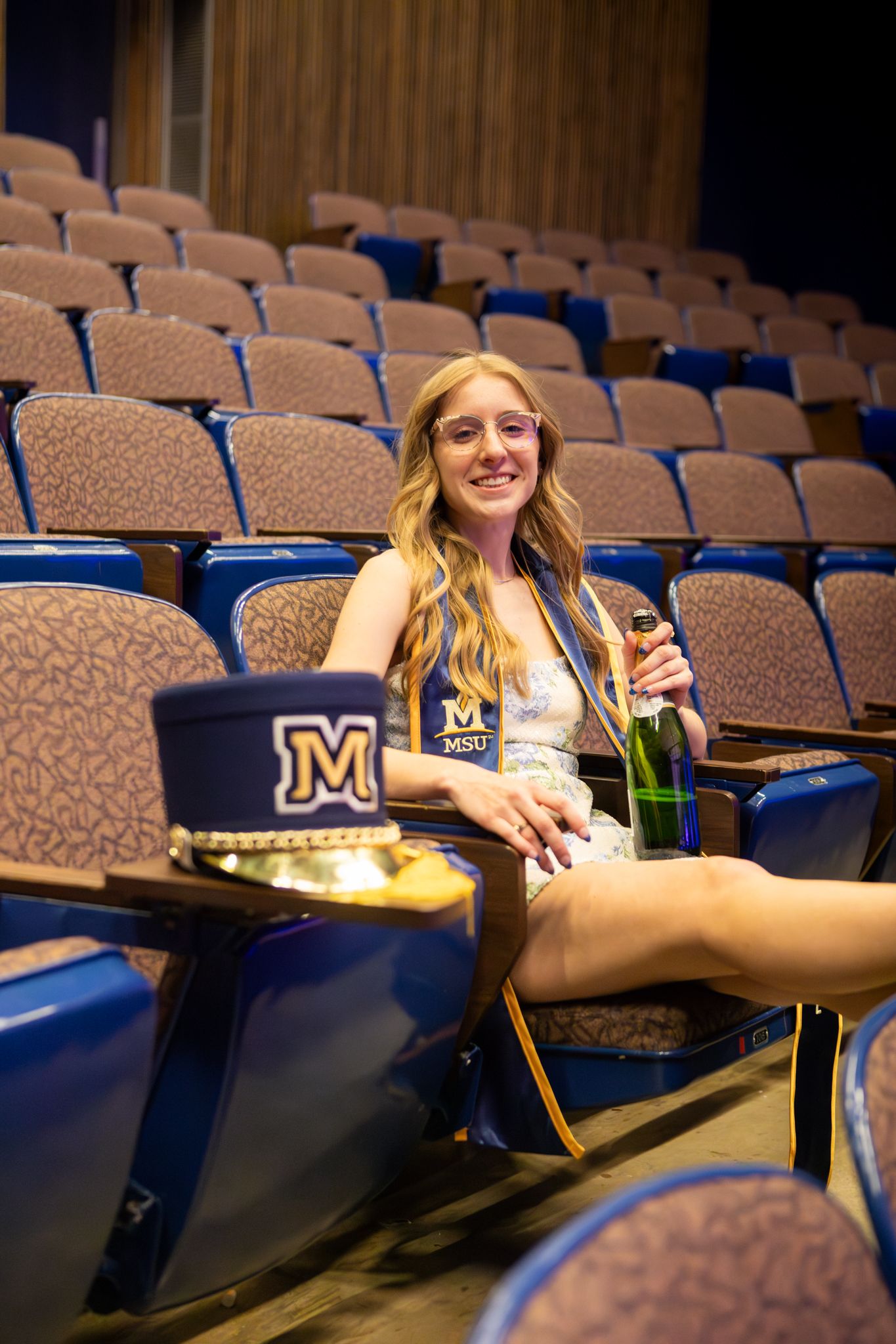 A Montana State University Grad sits in the music hall with her Spirit of the West Marching Band hat in Bozeman, MT.