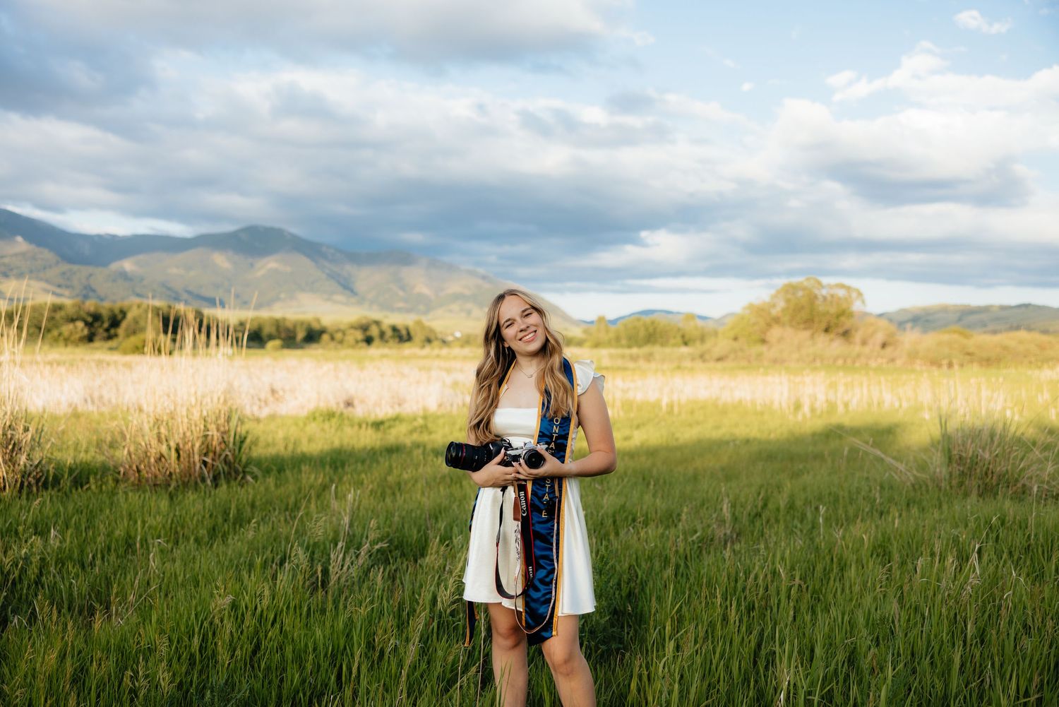 Sierrah Elizabeth holding her cameras in front of the mountains. Image by Mallory Jean Photography