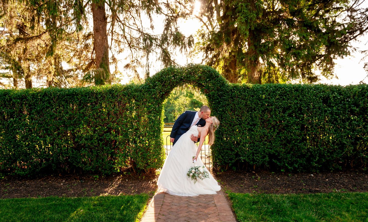 Romantic garden wedding photos with sunlight filtering through trees.