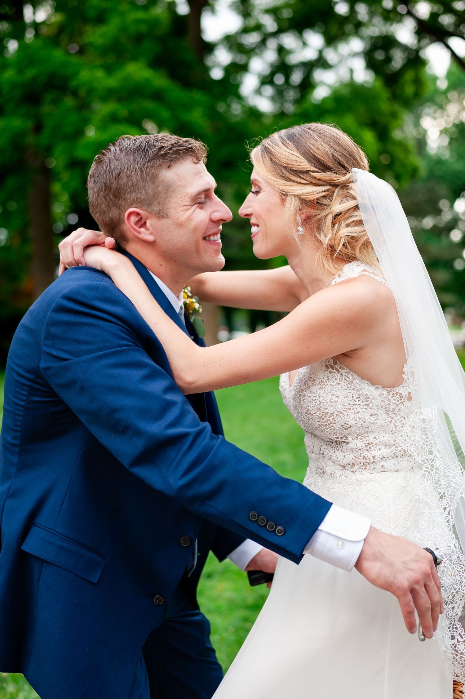 A joyful wedding moment captured outdoors with natural greenery in the background.