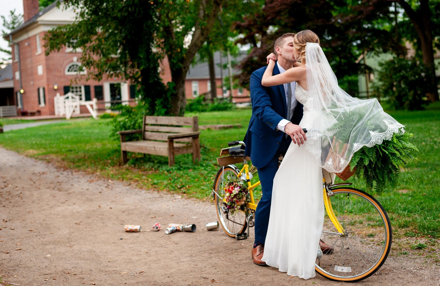A romantic wedding moment captured with a vintage bicycle in a park setting.