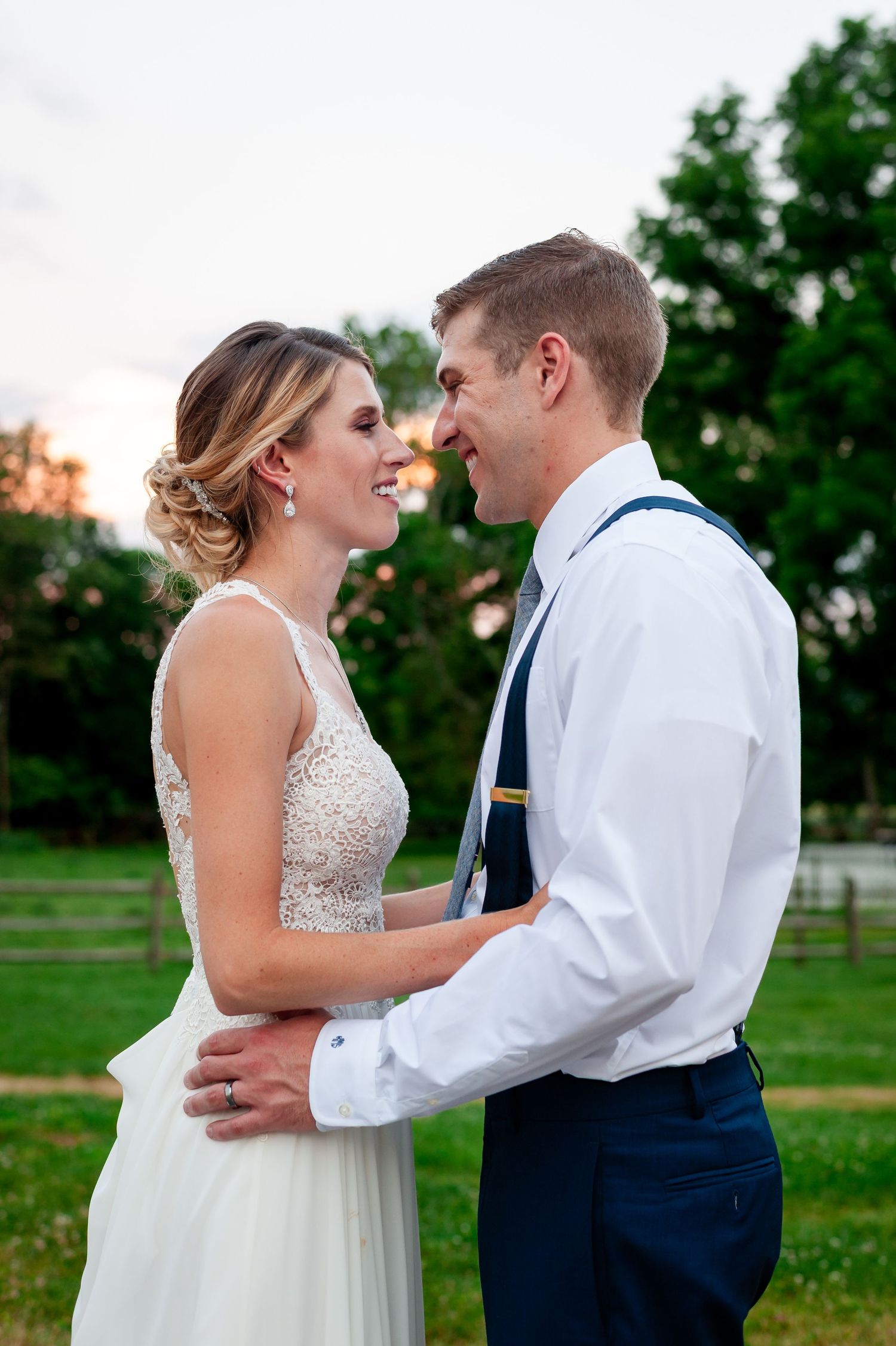 Intimate moment between newlyweds during golden hour in a garden setting.