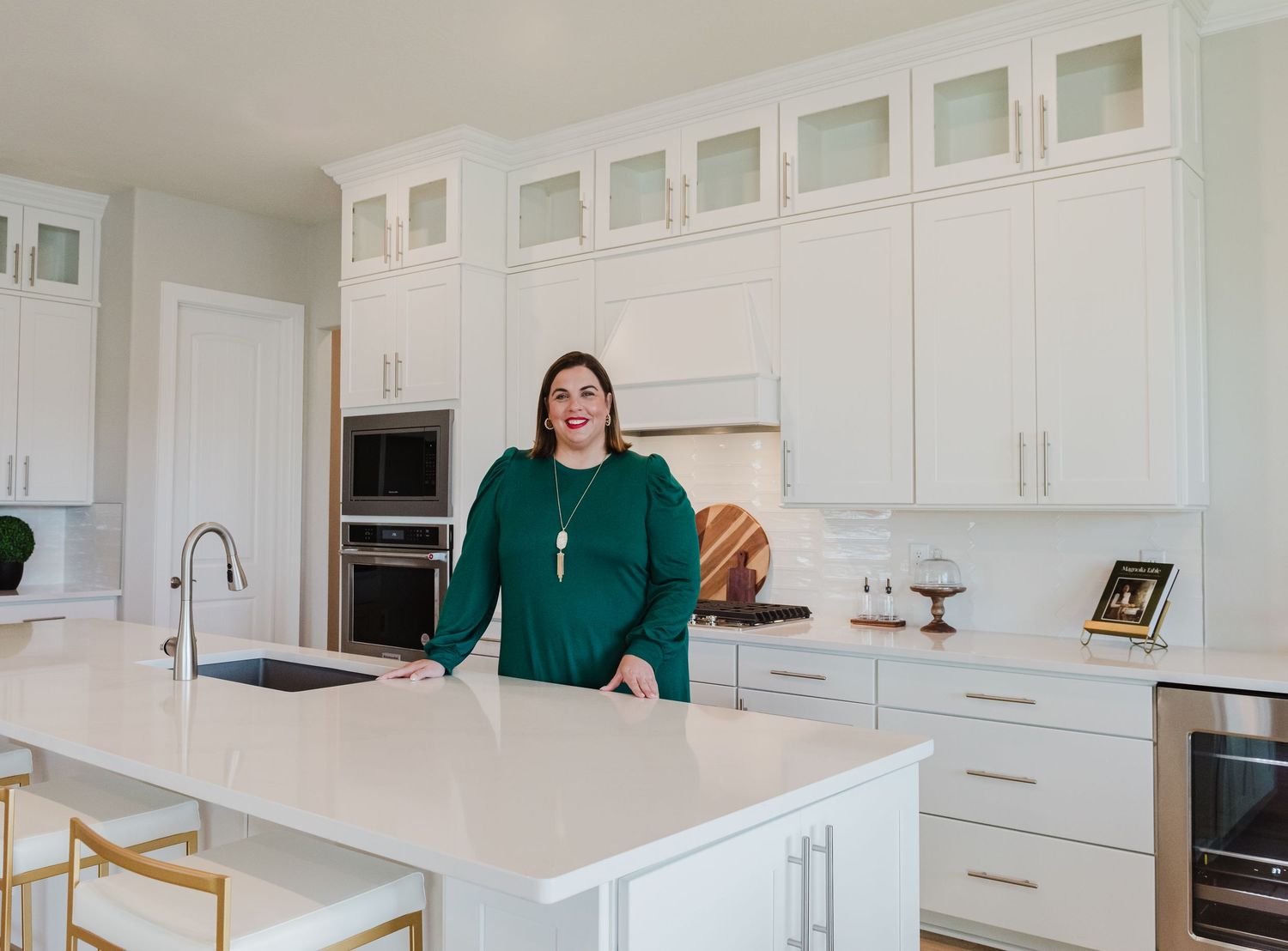 Modern white kitchen interior with floor to ceiling cabinets and island counter.