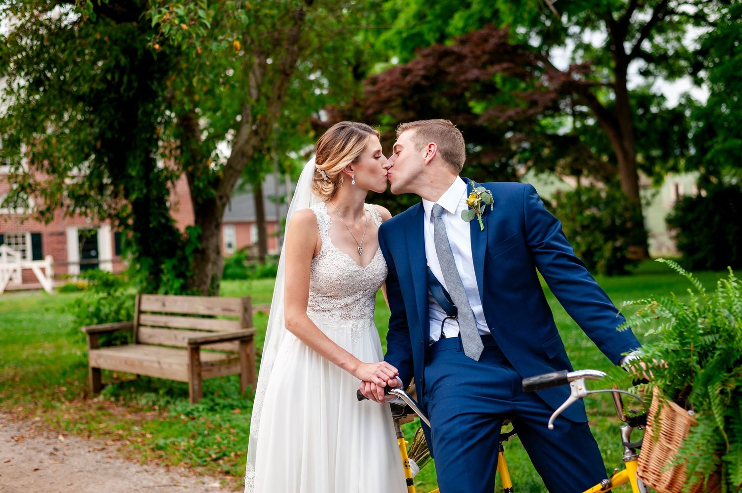 Wedding couple shares intimate moment in a garden setting surrounded by greenery.