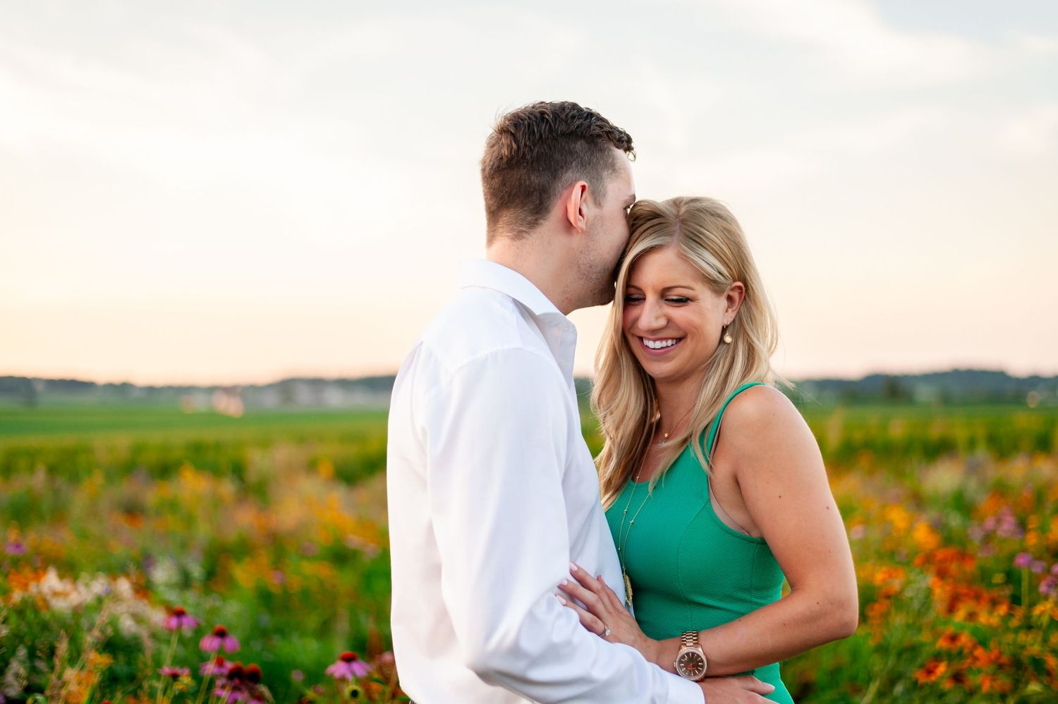 Couple shares joyful moment together in field of wildflowers during golden hour.