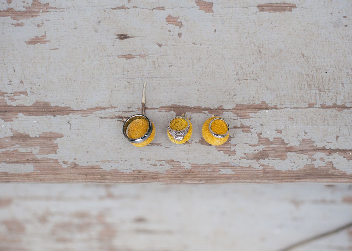 Three small yellow decorative objects arranged on weathered white wooden surface.