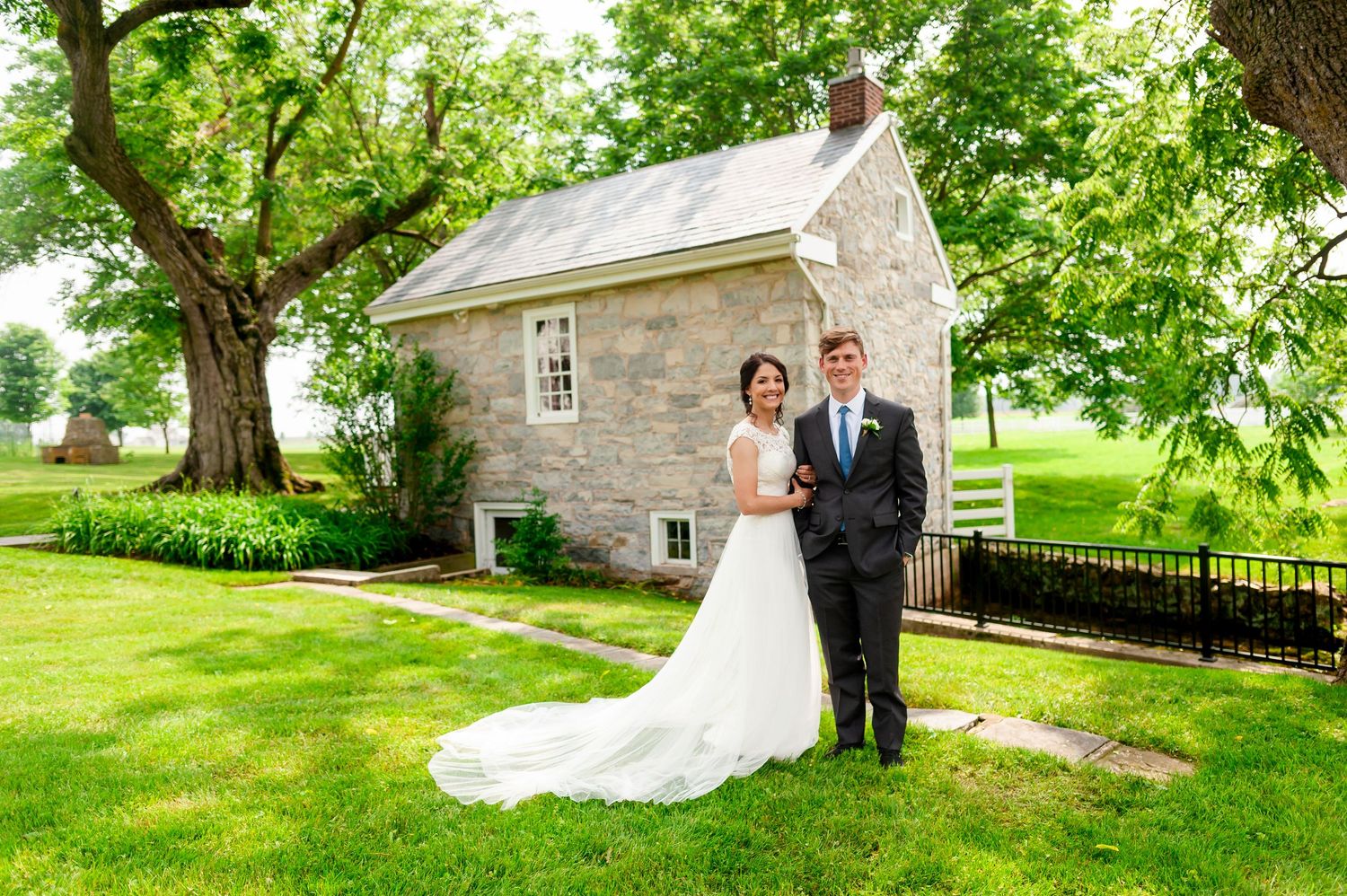 Stone building provides romantic backdrop for wedding photos in landscaped garden.