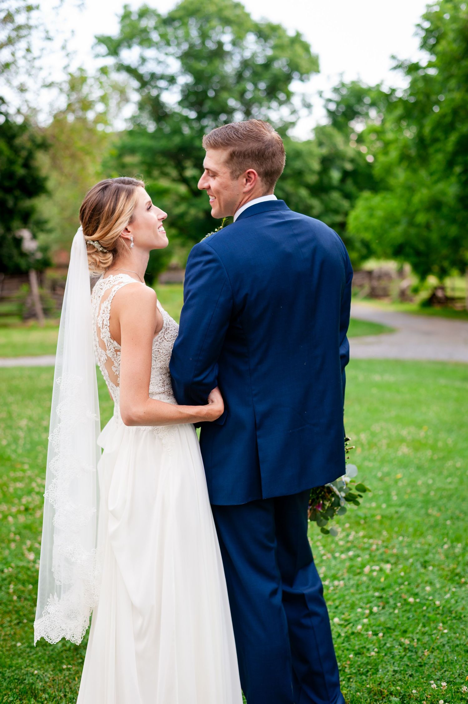 Couple shares tender moment during wedding first look in a scenic outdoor garden setting.