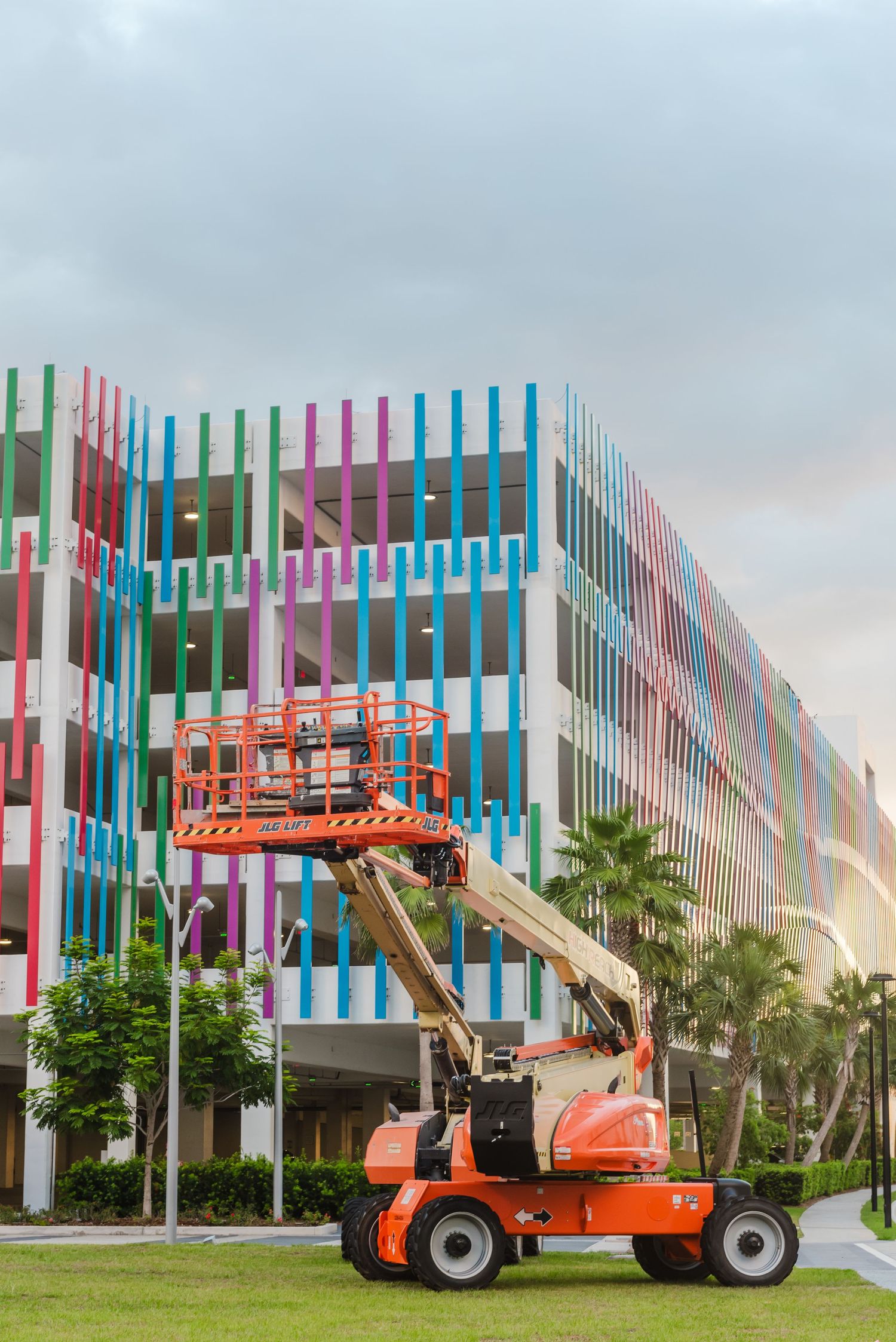 Colorful striped building facade with JLG Area work platform.