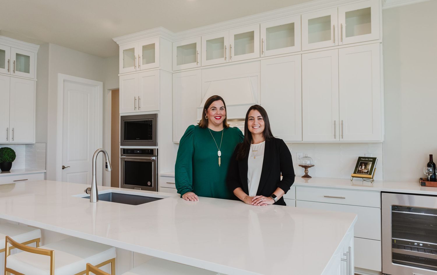 Two professionals standing at kitchen island in bright contemporary space.