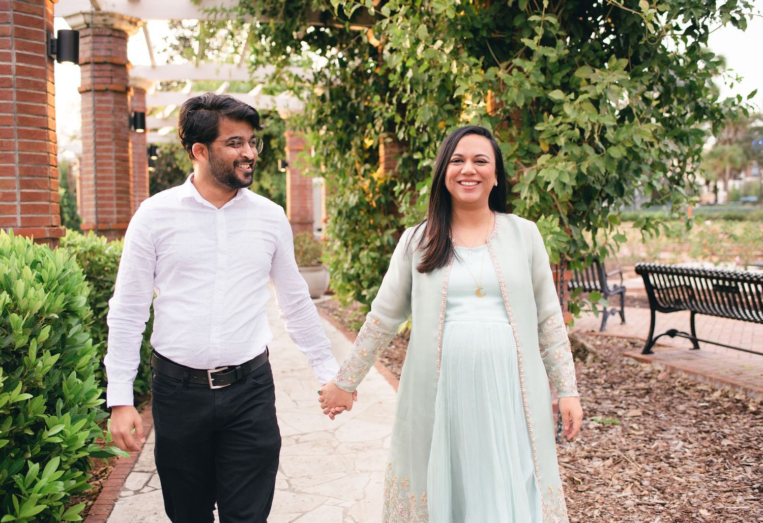 Engagement session captured along a garden path with white and mint colored summer clothing.