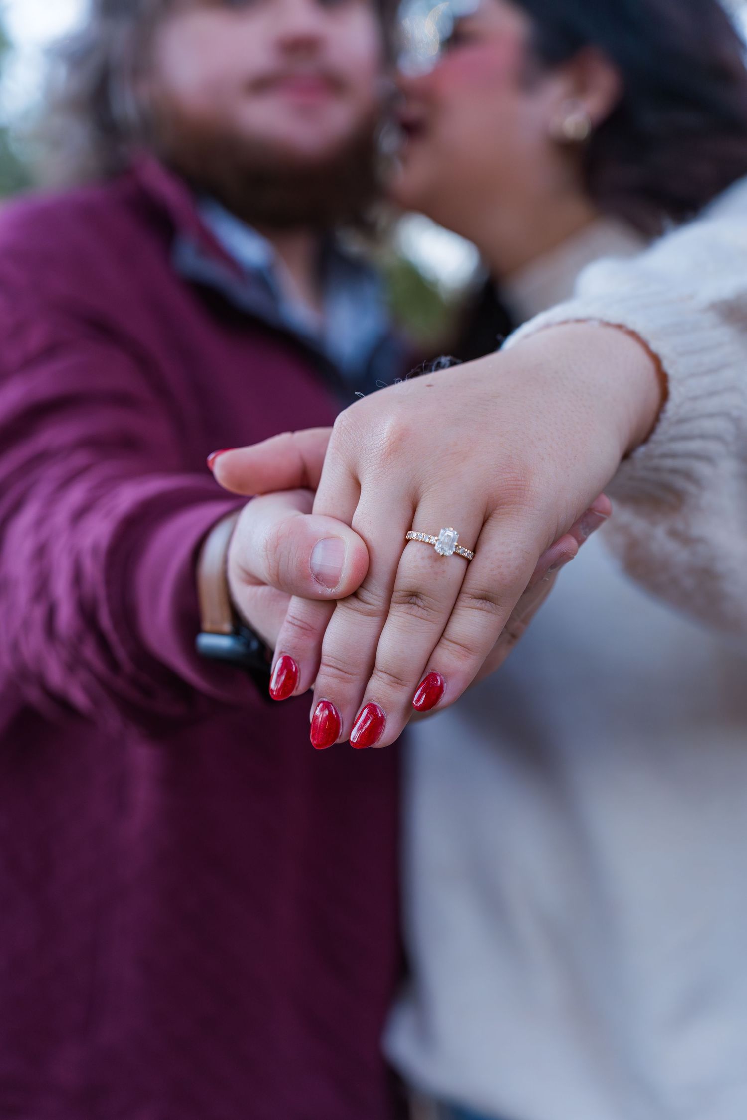 Close-up sequence of hands showing off a sparkling engagement ring with red nail polish.