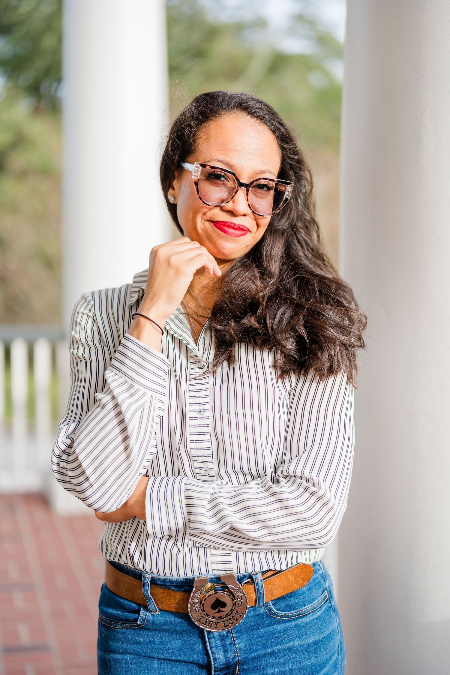 Lifestyle portraits with striped shirt and glasses against white columns.