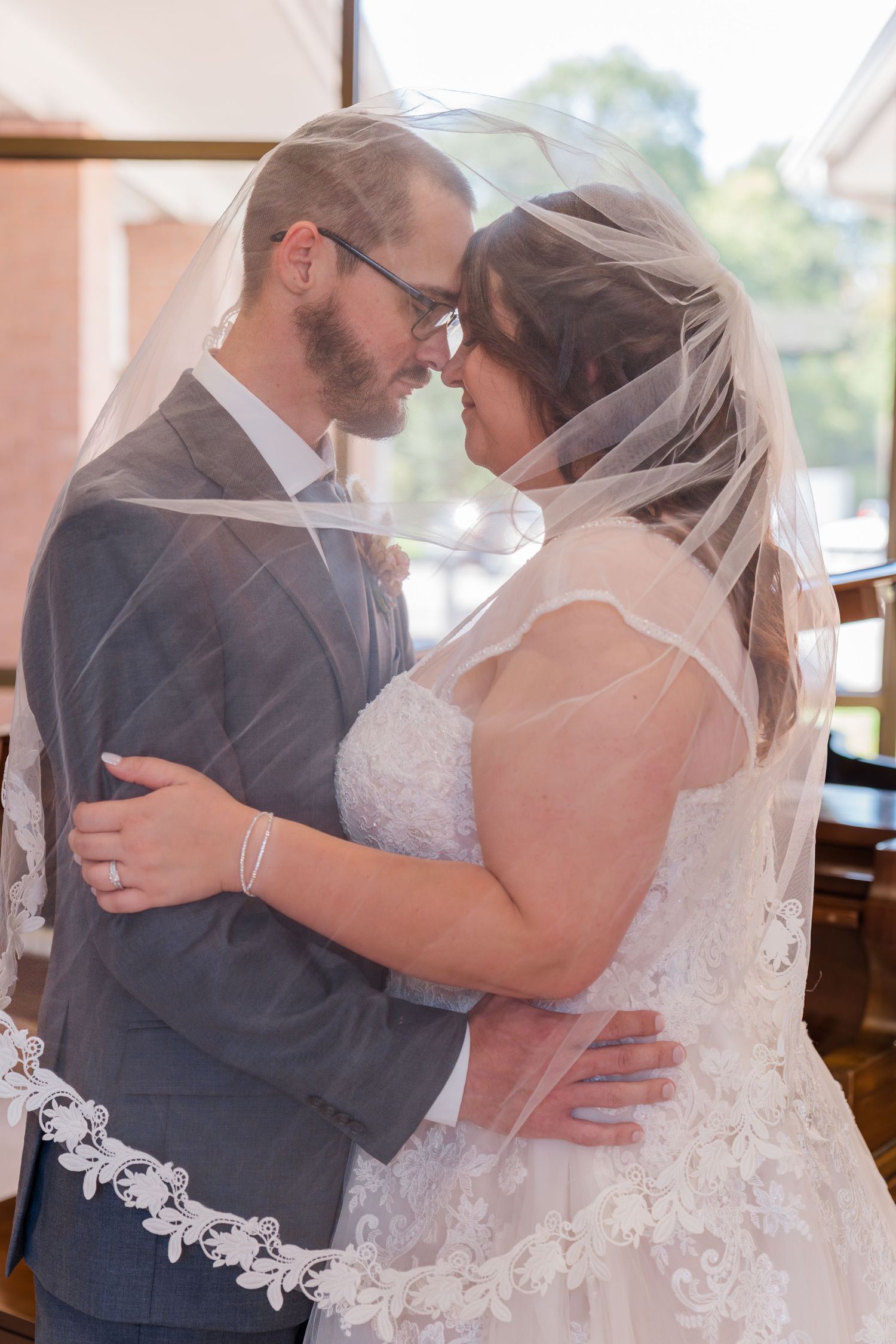 A romantic sequence of wedding photos shows a couple embracing in their formal attire with the bride wearing a lace veil.