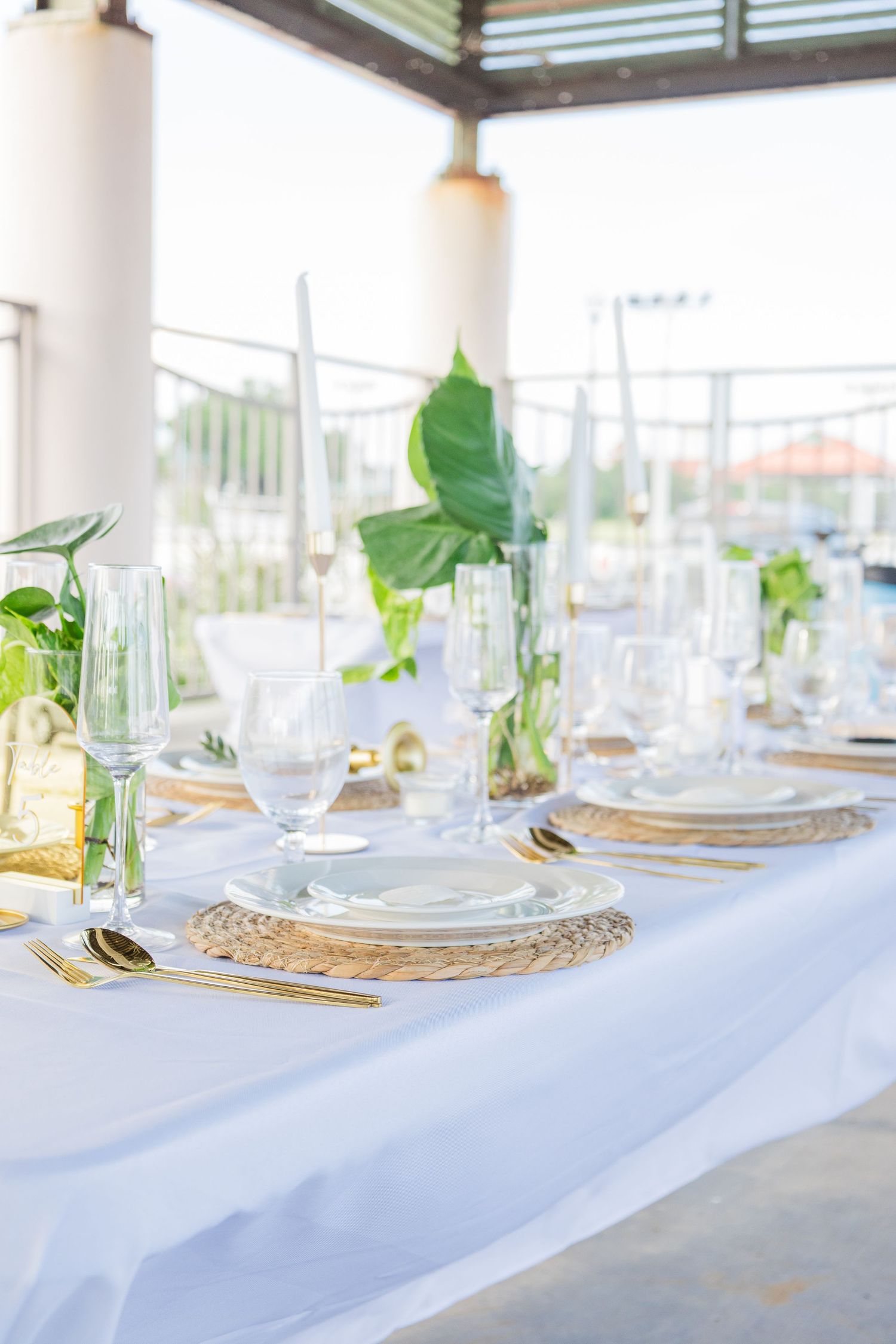 Elegant white tablescapes with place settings and greenery decor.